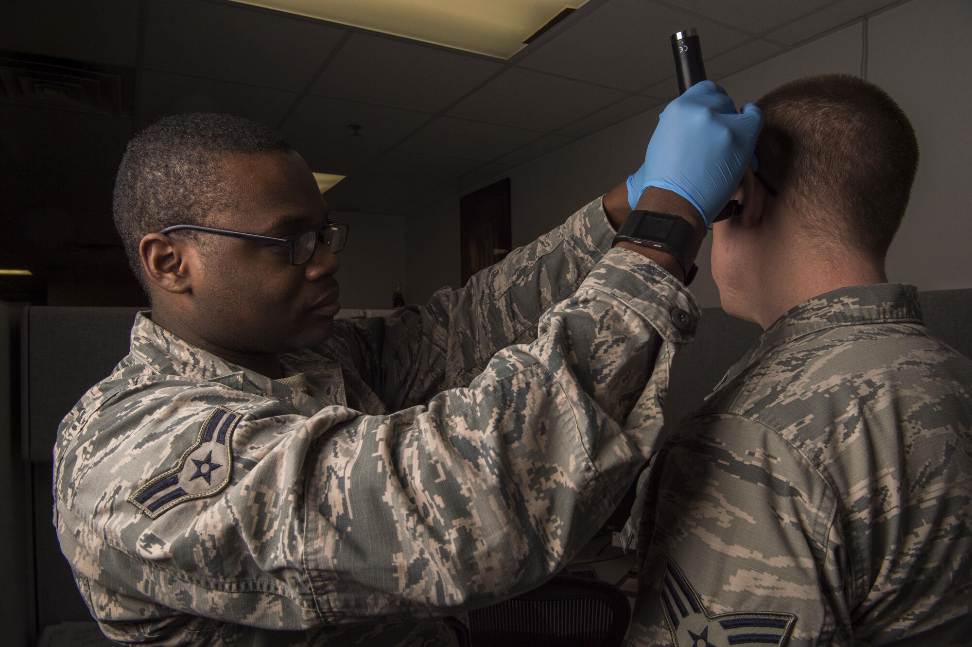 Airman 1st class Alvin Daniels, 90th Medical Operations Squadron public Health technician, performs a lighted ear inspection on a patient at F.E. Warren Air Force Base, Wyo., Jan. 20, 2017. The Air Force celebrates Biomedical Science Corps Appreciation Week Jan. 23 to 27. The Biomedical Science Corps is comprised of 15 medical Air Force Specialty Codes of which 10 are represented at F.E. Warren. (U.S. Air Force photo by Staff Sgt. Christopher Ruano)