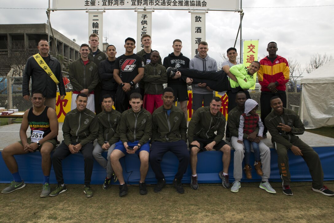 MARINE CORPS AIR STATION FUTENMA, OKINAWA, Japan – Marines pose with a local resident Jan. 21 prior to the Ginowan City Traffic Safety Relay Race at MCAS Futenma. Thirty-five teams from Ginowan City and teams from MCAS Futenma and the U.S Naval Hospital Okinawa participated in the yearly event. Teams from Ginowan City Fire Department placed first and second with the Marines coming in third, sparking a friendly competition for next years race.