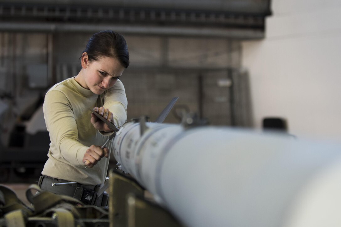 Air Force Airman 1st Class Gina Herringer-Koblack prepares an inert weapon for loading during the annual weapons load competition in Hangar One at Spangdahlem Air Base, Germany, Jan. 20, 2016. Herringer-Koblack is assigned to the 52nd Aircraft Maintenance Squadron. Air Force photo by Airman 1st Class Preston Cherry