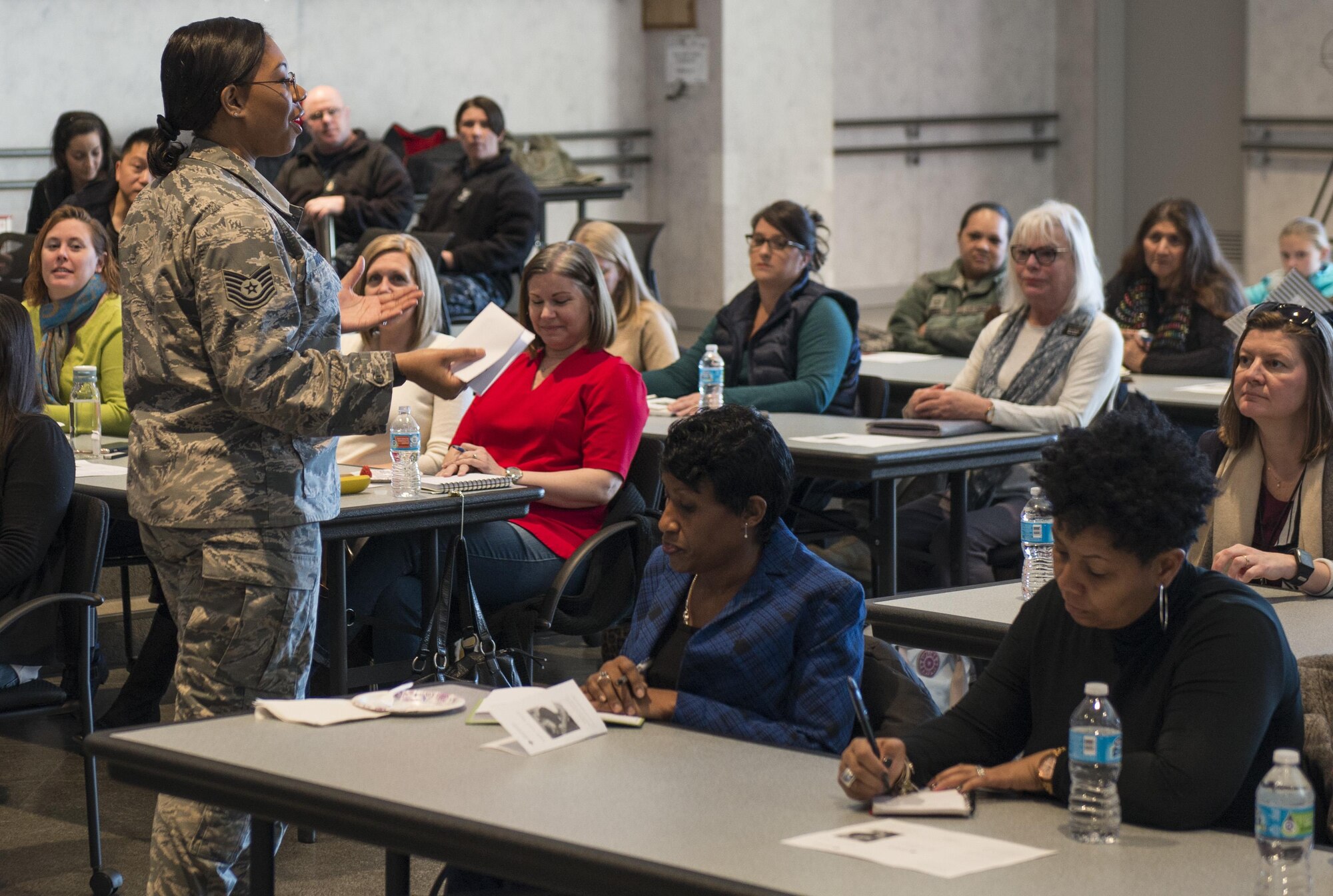 Tech. Sgt. Sherrell Moorer, 374th Force Support Squadron readiness NCO, briefs participants of a Noncombatant Evacuation Operation Townhall meeting Jan. 23, 2017, at Yokota Air Base, Japan. NEO is a mandatory or voluntary departure of civilian noncombatants and nonessential military personnel from danger in an overseas country. (U.S. Air Force Photo by Airman 1st Class Juan Torres)