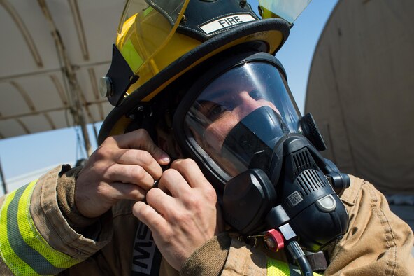 A 380th Expeditionary Civil Engineering Squadron firefighter properly secures his mask before a timed firefighter confidence course at an undisclosed location in Southwest Asia, Jan. 16, 2017. Wearing up to 75 pounds of equipment, participants completed nine stages during the course including a ladder climb, hose drag, sled pull, hose throw, equipment carry, forcible entry, hotel pack, equipment hoisting and rescue. (U.S. Air Force photo/Senior Airman Tyler Woodward)