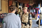 First Sgt. (Plutonier-major) Victor Balan walks a presence patrol at one of the local national bazaars on Bagram Airfield.  Balan talks with the shop keepers and patrons and keeps a keen eye out for any unusual activities or conditions.  The checks are routine requirements for a typical Provost Marshall military police patrol.  Balan is a member of the 4th Romanian Military Police Detachment from the Romanian Land Forces 265th MP Battalion, in Bucharest.