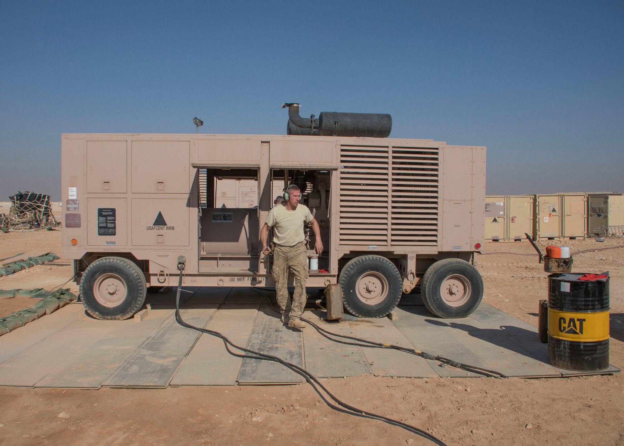 Staff Sgt. Gregory Speed, a 370th Air Expeditionary Advisory Group Detachment 1 electrician craftsman, exits a generator at Al Asad Air Base, Iraq Jan. 8, 2017. Preventive maintenance on these generators can take anywhere from an hour and a half to two hours to finish. (U.S. Air Force photo/Senior Airman Andrew Park)