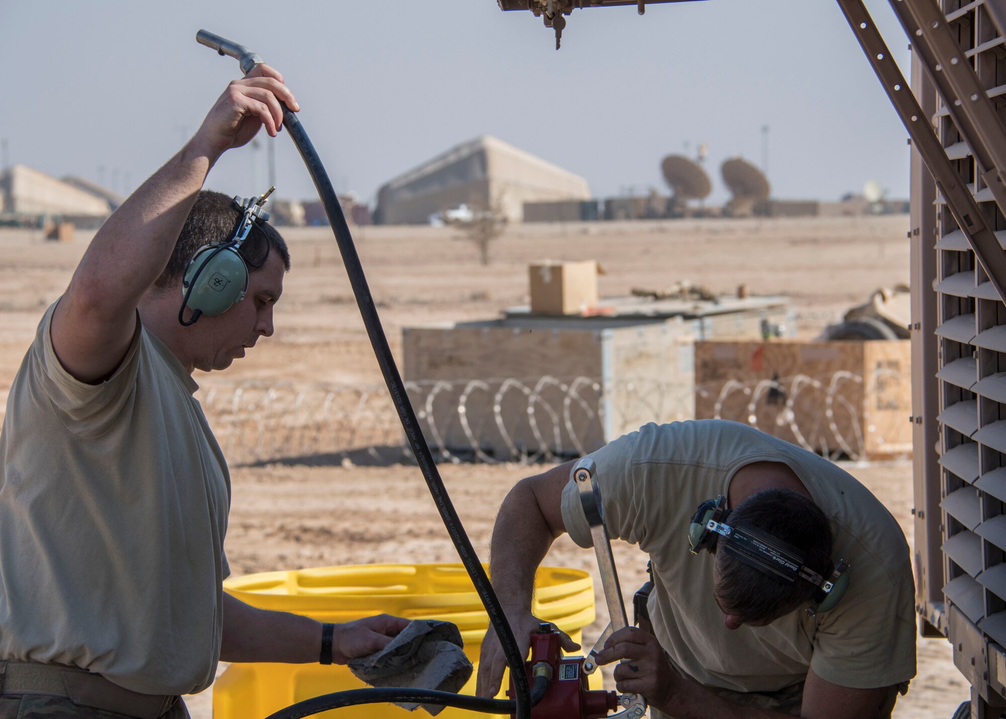 Staff Sgt. Abraham Wanner, a 370th Air Expeditionary Advisory Group Detachment 1 power production craftsman, left, and Staff Sgt. Gregory Speed, a 370th AEAG/Det 1 electrician craftsman, right, install a hand pump on an oil barrel at Al Asad Air Base, Iraq Jan. 8, 2017. Running the generators nonstop requires frequent servicing. (U.S. Air Force photo/Senior Airman Andrew Park)