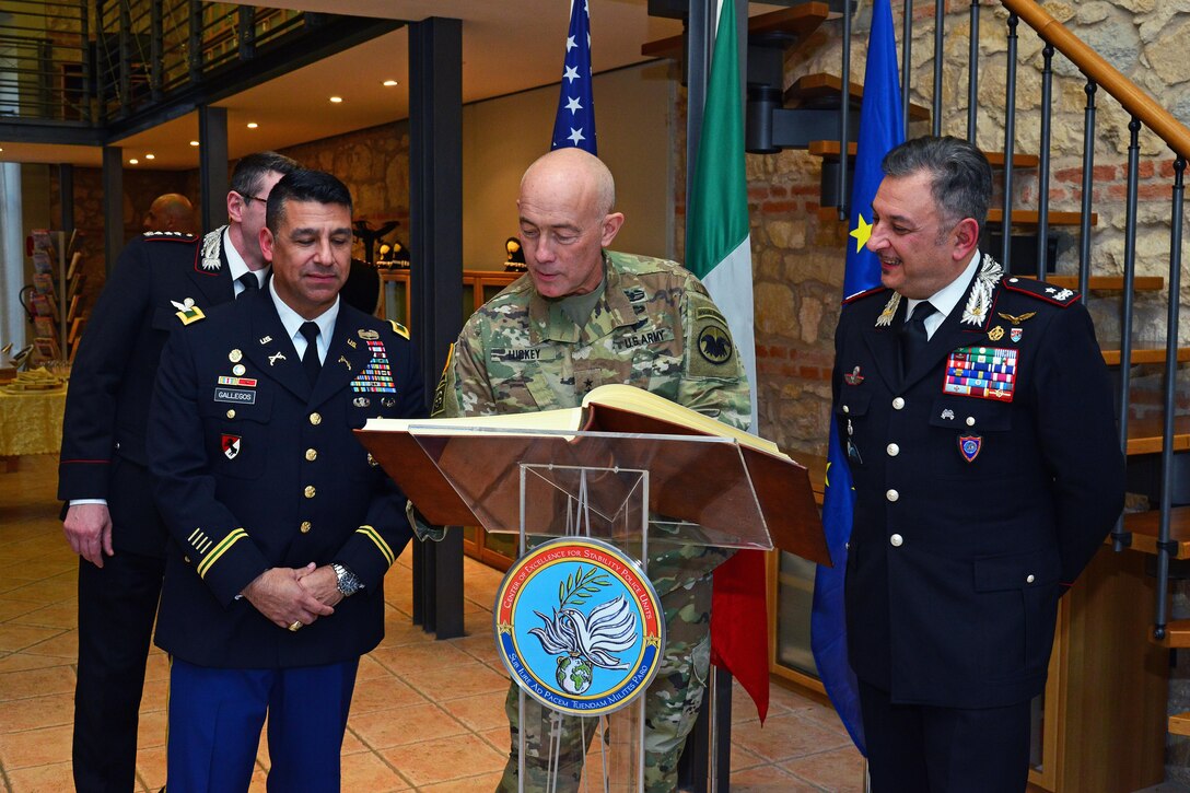 U.S. Army Col. Darius S. Gallegos (left), Center of Excellence for Stability Police Units (CoESPU) deputy director and Brig. Gen. Giovanni Pietro Barbano , (CoESPU) director, look Lt. Gen. Charles D. Luckey (center), Commanding General U.S. Army Reserve Command, sign the guestbook, during visit at Center of Excellence for Stability Police Units (CoESPU) Vicenza, Italy, January 20, 2017.(U.S. Army Photo by Visual Information Specialist Paolo Bovo/released)
