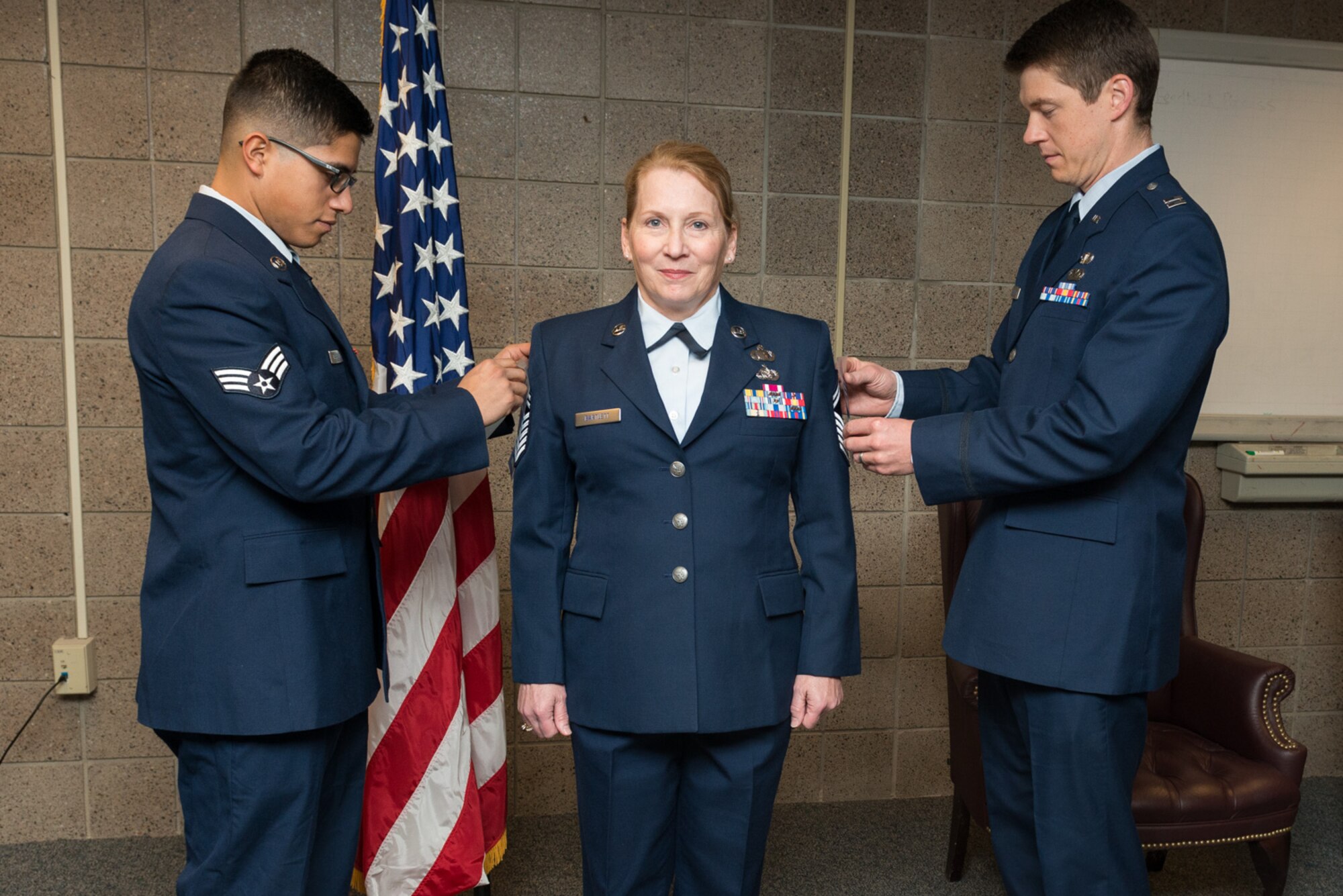 Senior Airman Mike Navarrete, left, and Captain Jason Boerboom, right, tack Chief Master Sgt. stripes onto Chief Master Sgt. Anna Bartlett, Financial Management superintendent with the 934th Airlift Wing, during a promotion ceremony Jan. 7 at Minneapolis-St. Paul International Airport Air Reserve Station, Minn. Bartlett has served 32 years in the Air Force.