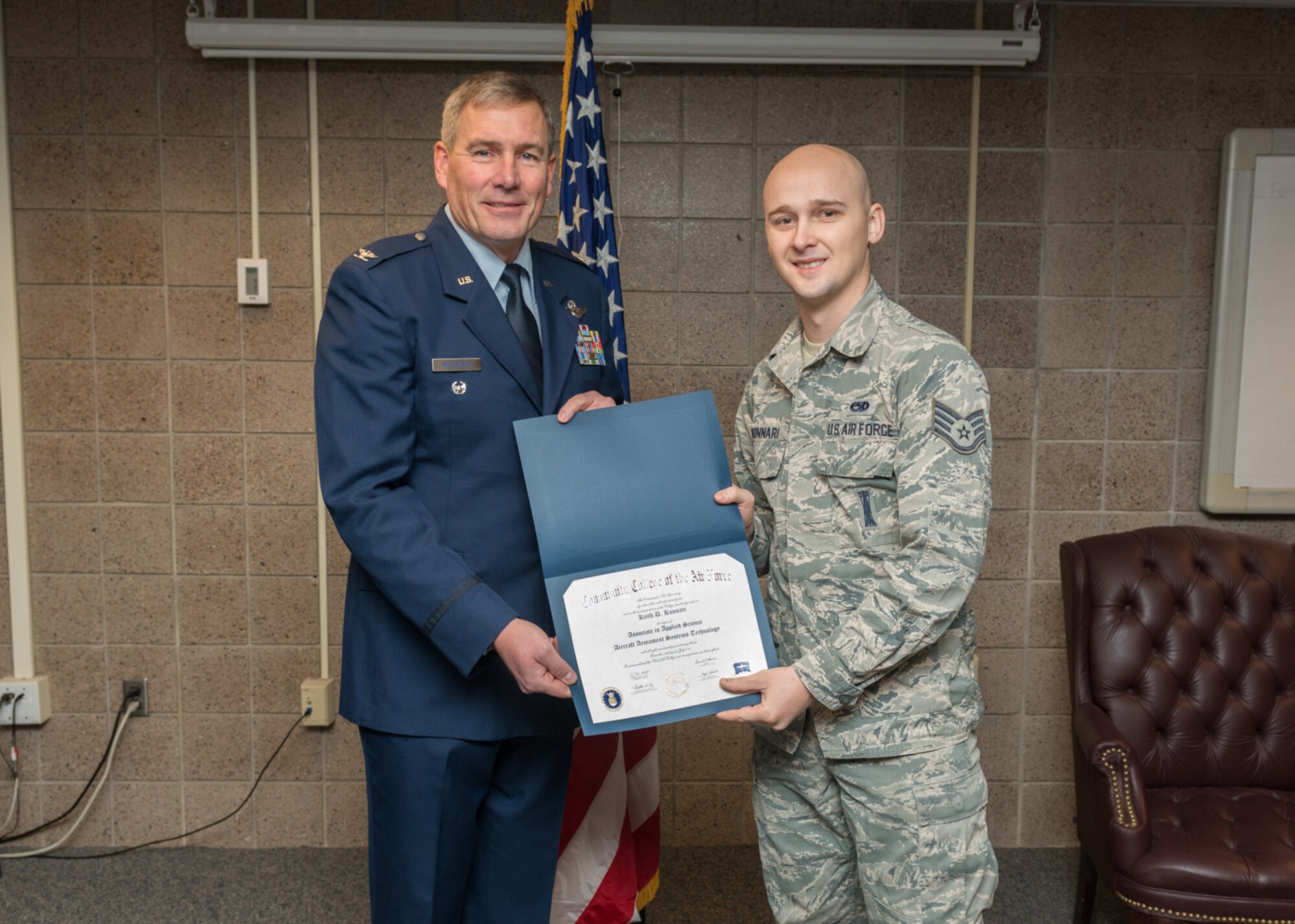 Col. Timothy Wollmuth, 934th Airlift Wing vice commander, presents Staff Sgt. Keith D. Kunnari, occupational safety specialist with the 934th Airlift Wing, his associate in applied science degree in aircraft armament systems technology Jan. 7 at Minneapolis-St. Paul International Airport Air Reserve Station, Minn.