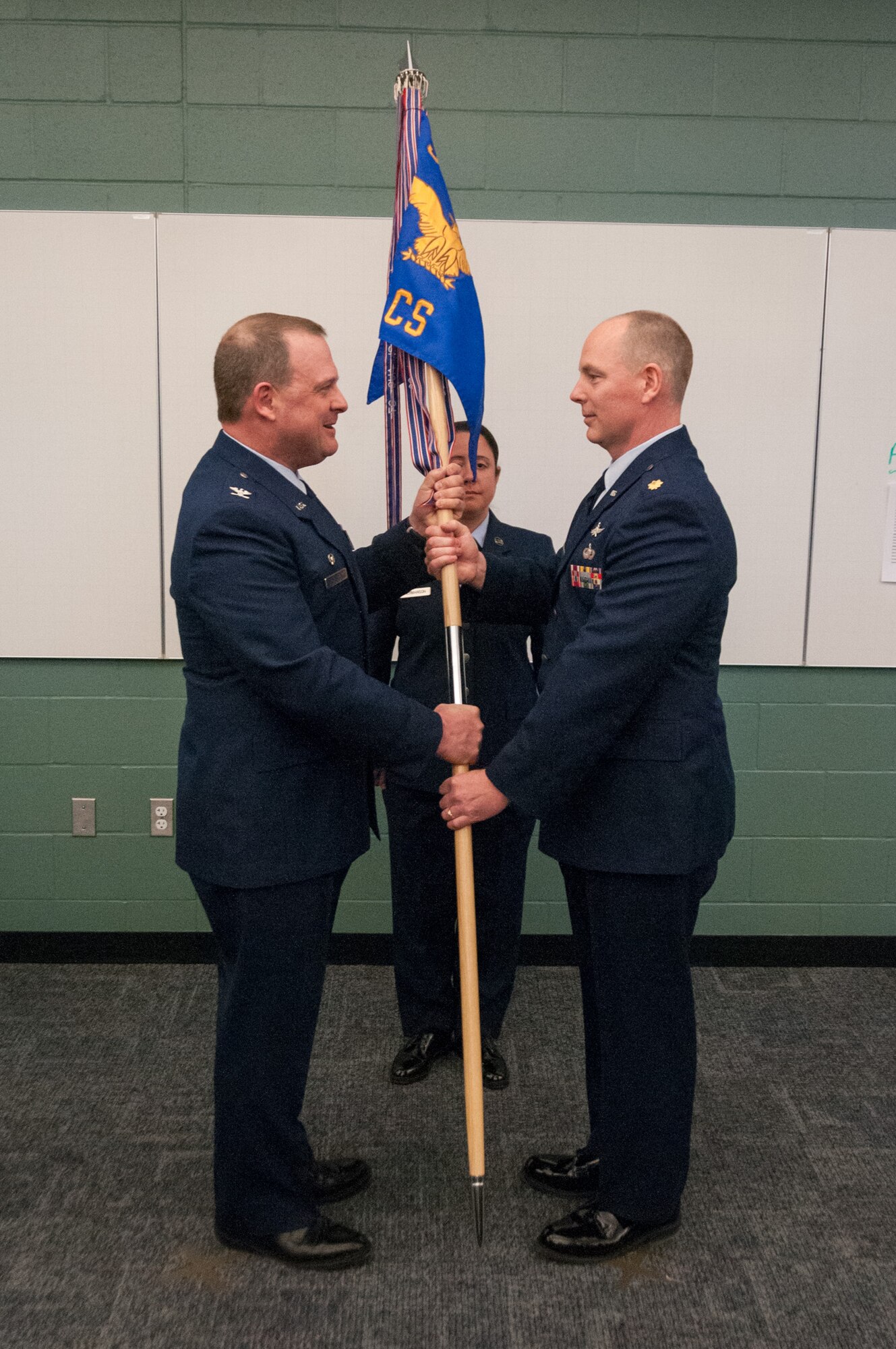 Col. Craig Petersen, 934th Mission Support Group commander, passes the 934th Communications Squadron unit flag to Maj. Patrick McDonald, 934 CS commander, Jan. 7 at Minneapolis-St. Paul International Airport Air Reserve Station, Minn. The passing of the flag symbolizes passing command of the unit. 