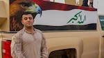 Cpl. Ali J. Mohammed, a Baghdad, Iraq native and a supply Marine with 3rd Battalion, 7th Marine Regiment, Special Purpose Marine Air-Ground Task Force-Crisis Response-Central Command, stands in front of the painting an Iraqi flag while in Northern Iraq, Dec. 26, 2016. Mohammed, fluent in Arabic, has strengthened the partnership between SPMAGTF Marines and Iraqi military members by translating pertinent information to support their operations. SPMAGTF Marines enable Combined Joint Task Force-Operation Inherent Resolve with security forces, strikes, and advise and assist teams, all of which support the Iraqis in their efforts to defeat ISIL.