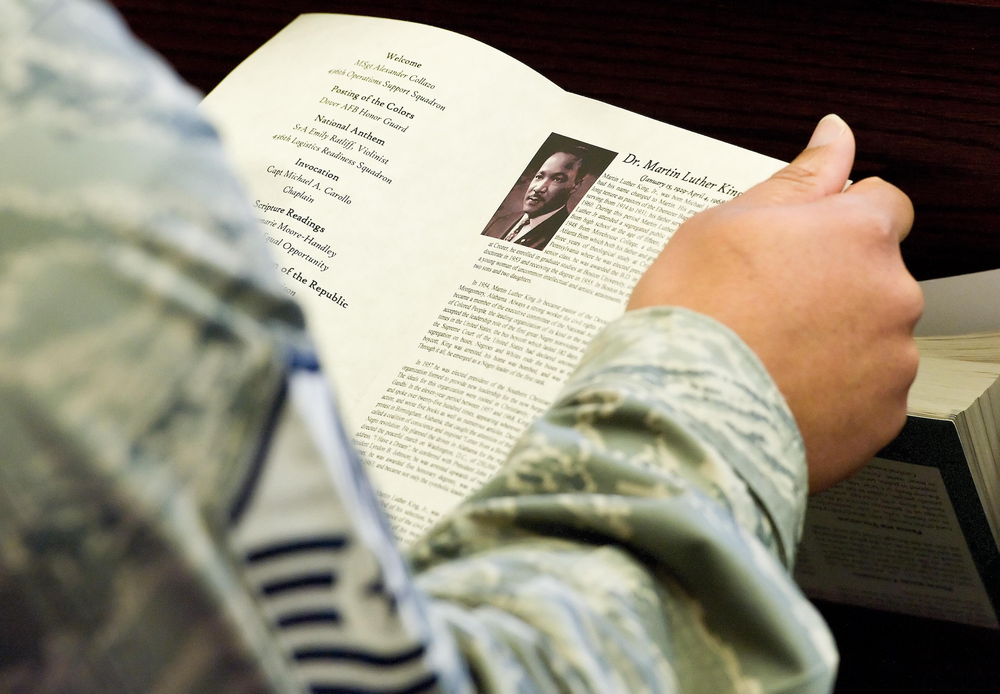 A Team Dover member reads the program for a tribute to Dr. Martin Luther King, Jr., Jan. 19, 2017, at the base chapel on Dover Air Force Base, Del. This year, Martin Luther King Jr. Day was officially recognized Jan. 16, 2017. (U.S. Air Force photo by Roland Balik)