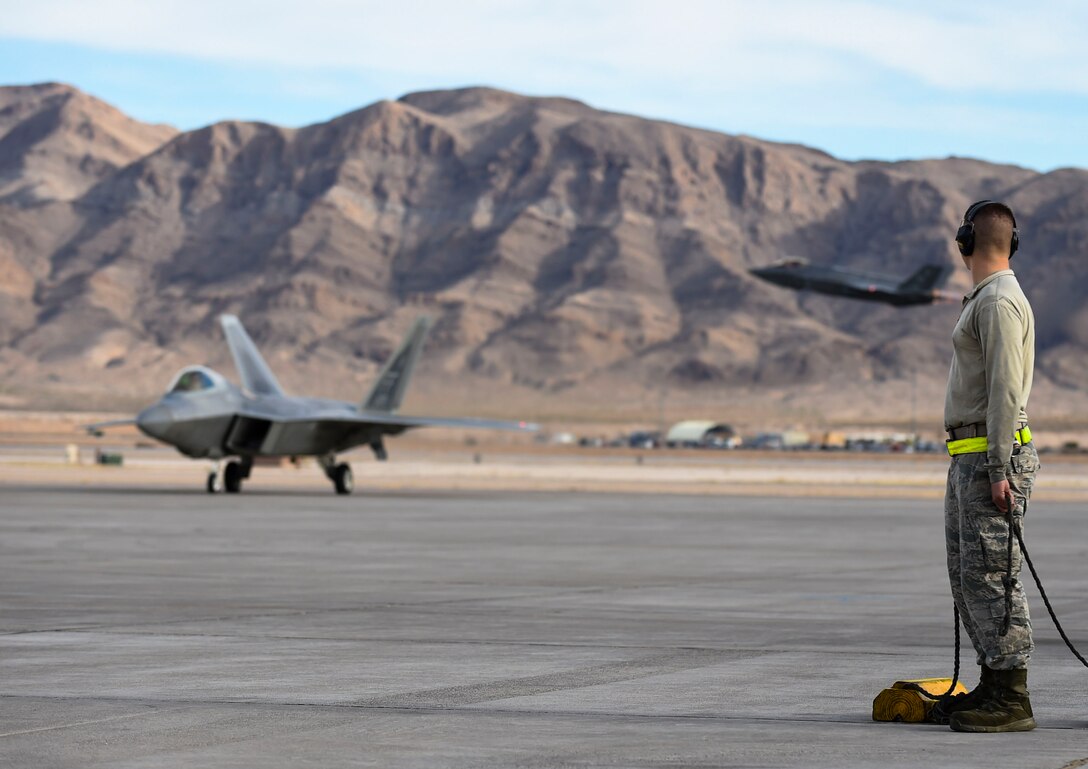 U.S. Air Force Airmen with the 1st Aircraft Maintenance Squadron prepare to taxi F-22 Raptor at Nellis Air Force Base, Nev., Feb. 18, 2017. The aircraft assigned to  Langley Air Force Base, Va.'s, 1st Fighter Wing will conduct air combat training sorties with various aircraft including the F-35 Lightning II during Red Flag 17-1. (U.S. Air Force photo by Staff Sgt. Natasha Stannard)