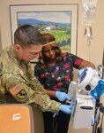 Staff Sgt. Alfredo Herrera Jr. (left), noncommissioned officer in charge of 2 East, works with Jenedra Curry (right), registered nurse on 2 East, to set up an intravenous drip for a patient. Brooke Army Medical Center launched a new program Jan. 17 to help increase the readiness of enlisted health care specialists who serve within the organization. The 68W Utilization Program will allow medics to practice the skills they need to maintain their core competencies so they are ready if deployed downrange.