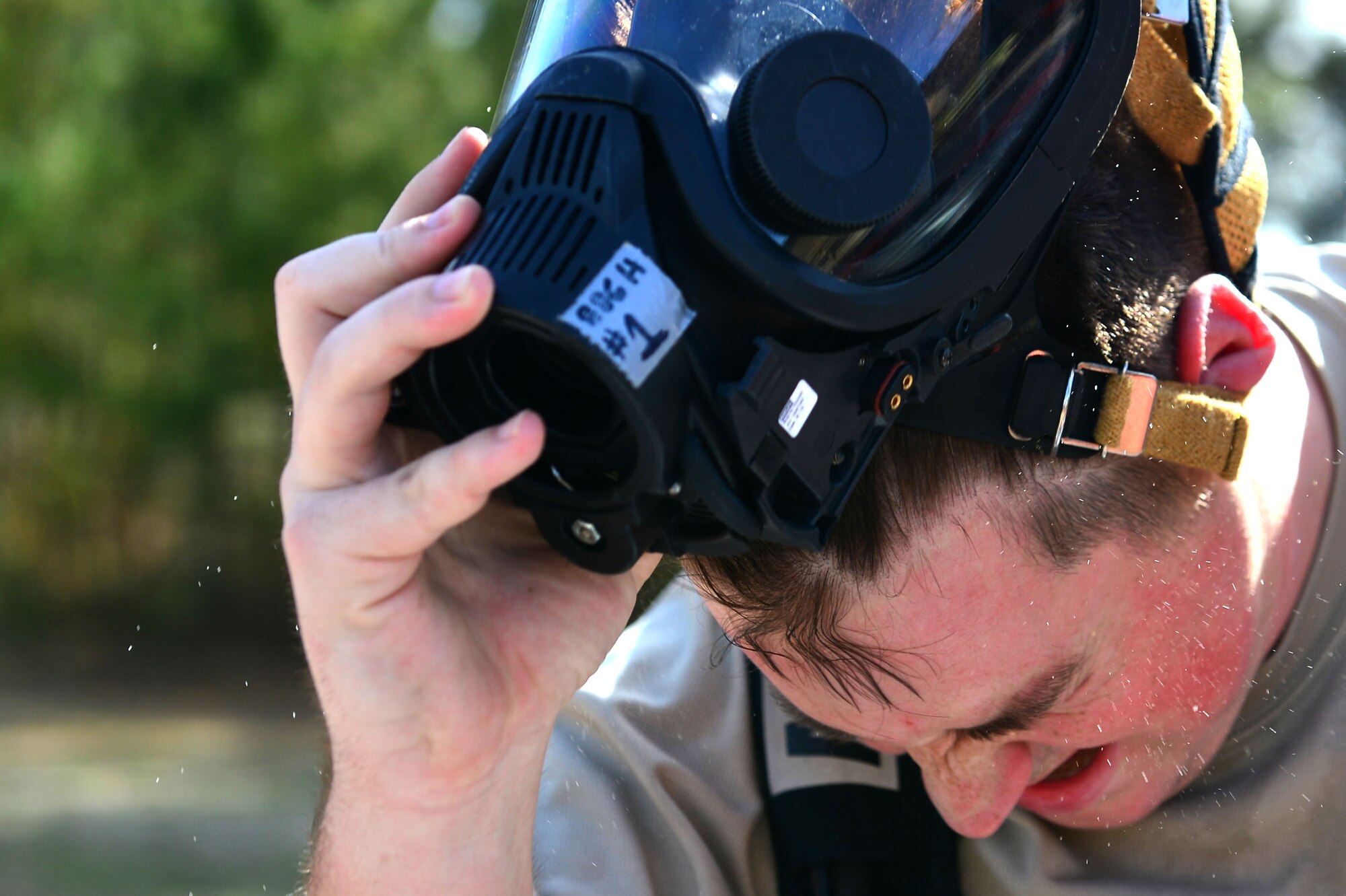 U.S. Air Force Senior Airman Nathan McKee, 20th Aerospace Medicine Squadron bioenvironmental engineer journeyman, removes his respiration device at the conclusion of a hazardous material training (HAZMAT) at Shaw Air Force Base, S.C., Jan. 19, 2017. At the conclusion of the training, participating Airmen went through a decontamination line and removed all HAZMAT gear. (U.S. Air Force photo by Airman 1st Class Christopher Maldonado)