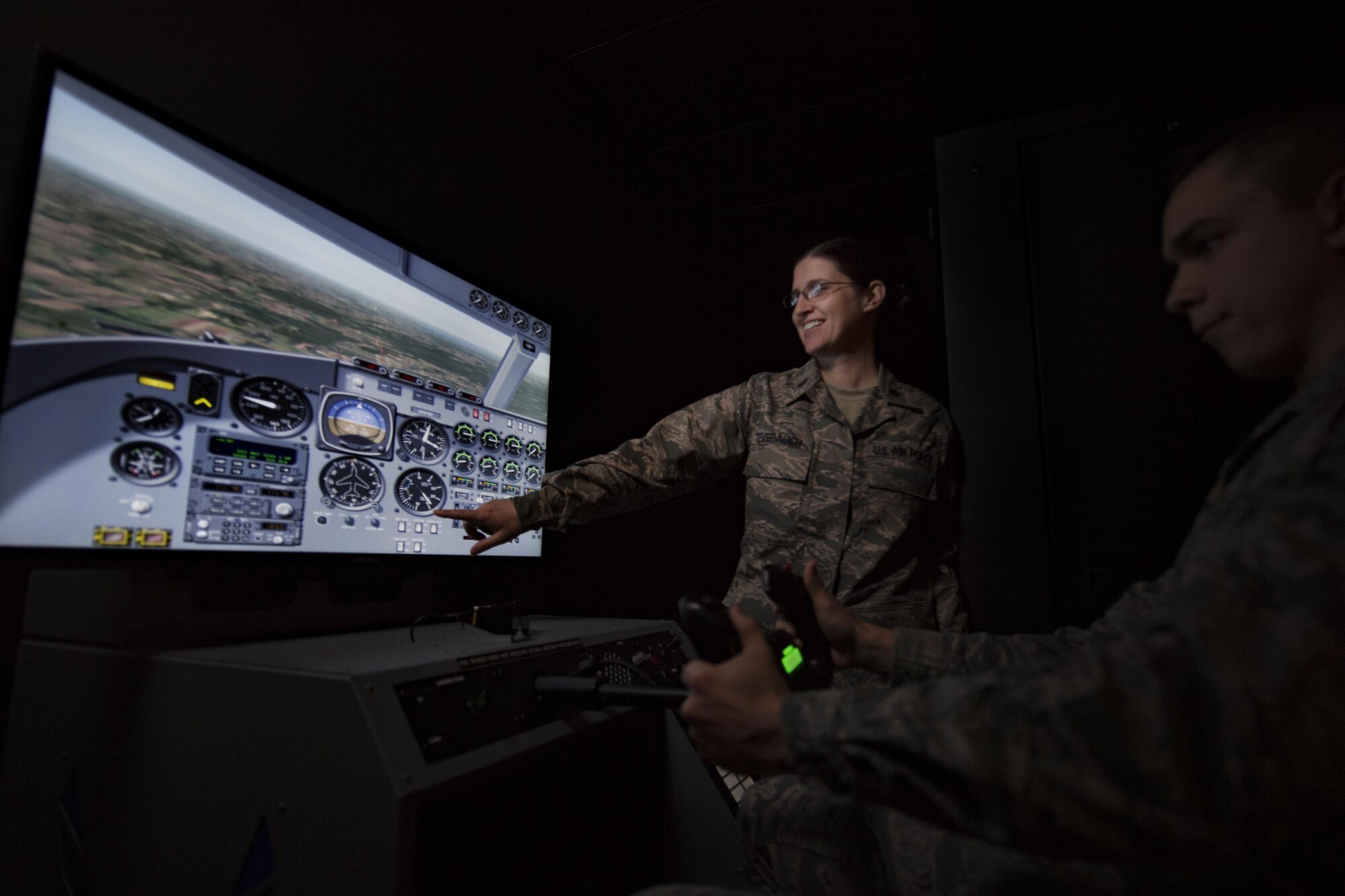 Maj. Heather Tevebaugh, 23d Aerospace Medicine Squadron aerospace physiologist assists Airman 1st Class Chase Young, 23d AMDS bioenvironmental technician, with a flight simulator, Jan. 18, 2016, at Moody Air Force Base, Ga. Aerospace physiologists manage specialized physiology support programs and procedures that ensure flight crews are prepared for high altitudes. In the Air Force, there are currently 118 active duty and three Air Force reservist aerospace physiologists. (U.S. Air Force photo by Airman 1st Class Daniel Snider)
