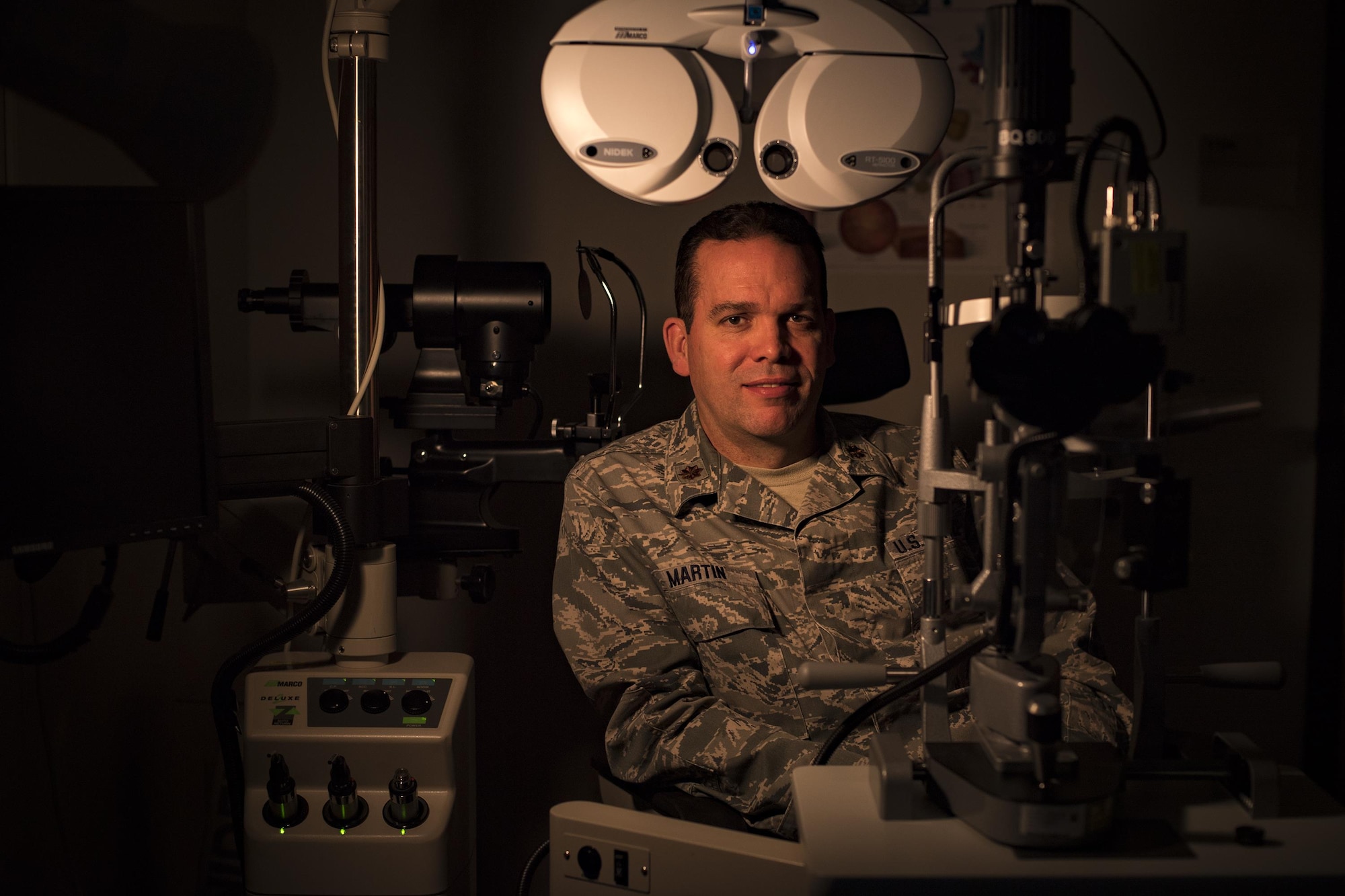 Maj. Scott Martin, 23d Aerospace Medicine Squadron optometry flight commander, poses for a photo with various pieces of optometry equipment, Jan. 19, 2016, at Moody Air Force Base, Ga. Optometrists are responsible for examining, diagnosing, treating and managing diseases and disorders of the visual system. In the Air Force, there are currently 136 active duty, 74 Air Force reservist and 90 Air National Guard optometrists. (U.S. Air Force photo by Airman 1st Class Daniel Snider)