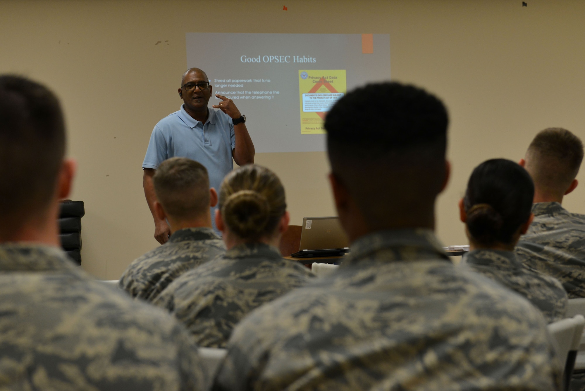 Karl Johnson, 20th Security Forces Squadron trainer, demonstrates answering the phone at Shaw Air Force Base, S.C., Jan. 18, 2017. Johnson explained proper operational security techniques for speaking on the telephone during an OPSEC brief. In the classroom, the Airmen also went over identification procedures as well as each of the less-lethal weapons used by the 20th SFS. (U.S. Air Force photo by Airman 1st Class Destinee Sweeney)