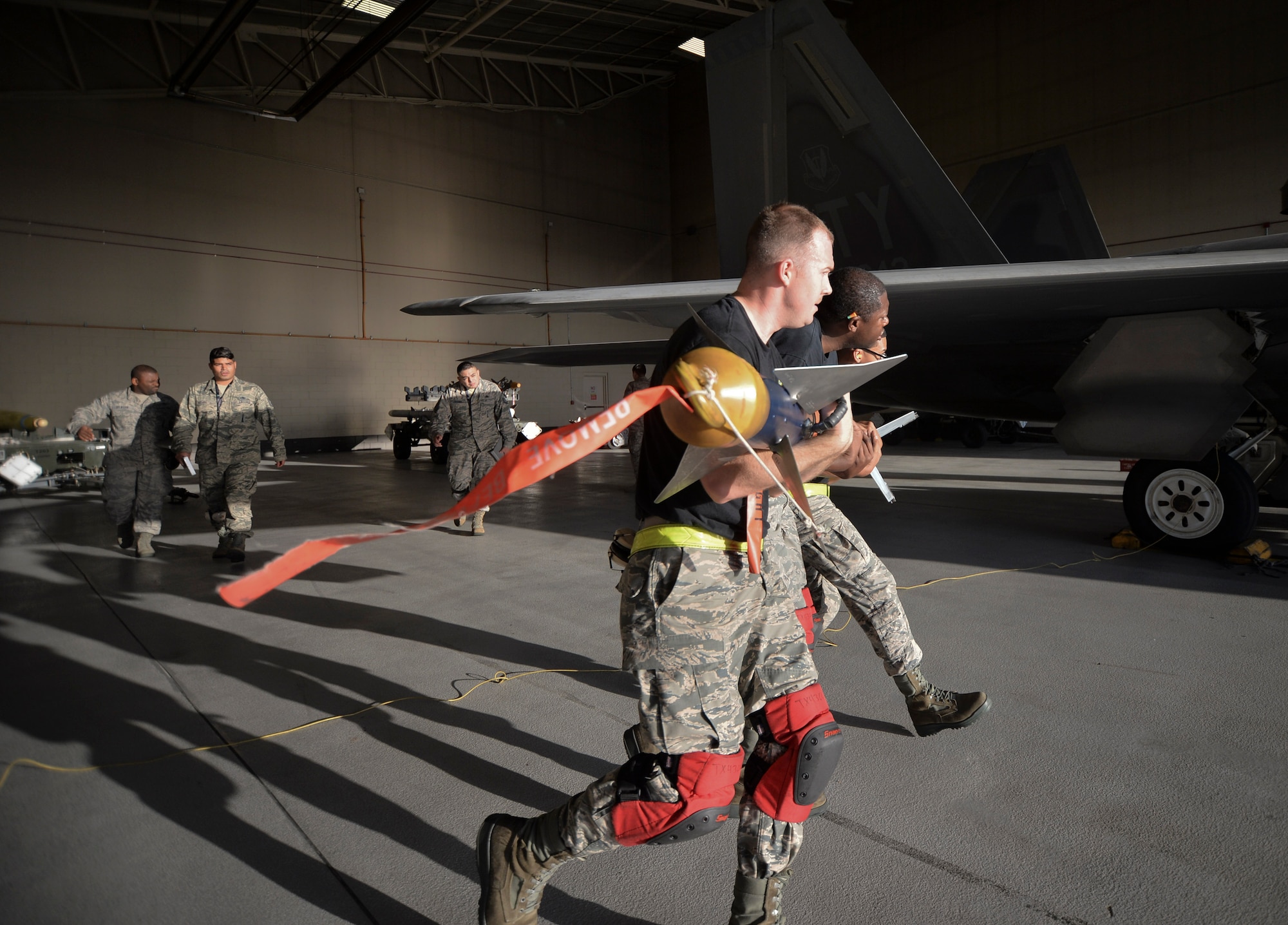U.S. Air Force Airmen from the 43rd Aircraft Maintenance Unit carry a training missile to manually load into an F-22 Raptor during the Load Crew of the Year competition at Tyndall Air Force Base, Fla., Jan. 20, 2017. Twelve Airmen from the 43rd AMU and the 95th AMU competed against each other in four teams of three for the award. (U.S. Air Force photo by Tech. Sgt. Javier Cruz/Released)