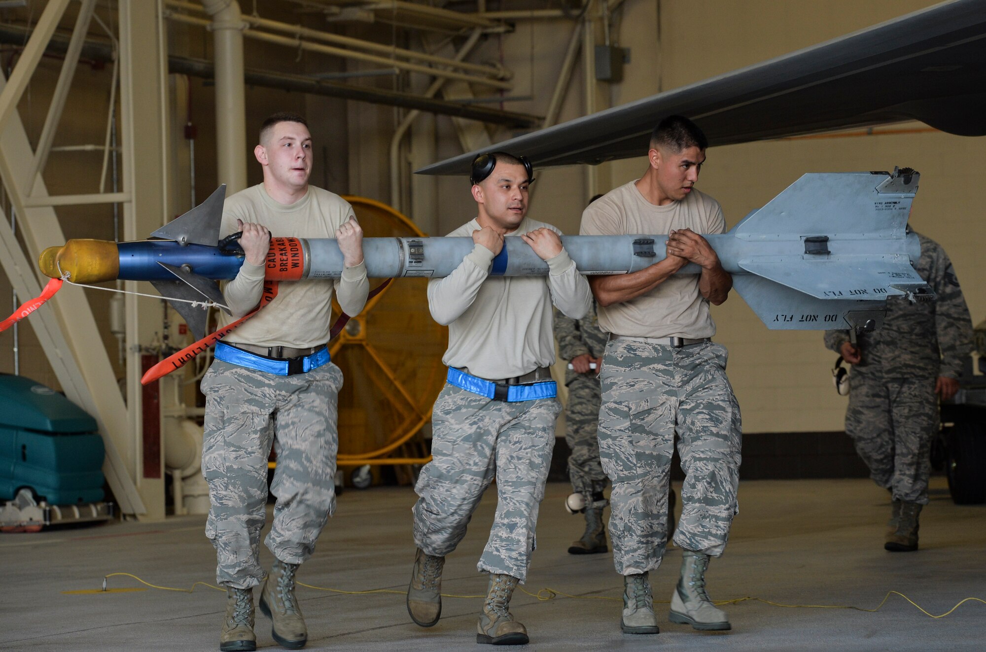 U.S. Air Force Staff Sgt. Vincent A. Miller, Staff Sgt. Michael A. Avalos and Senior Airman Jack T. Crane from the 95th Aircraft Maintenance Unit, carry a training missile to manually load into an F-22 Raptor during the Load Crew of the Year competition at Tyndall Air Force Base, Fla., Jan. 20, 2017. The teams of Airmen completed uniform inspections, a knowledge test and a 90 minute loading evaluation. (U.S. Air Force photo by Tech. Sgt. Javier Cruz/Released)
