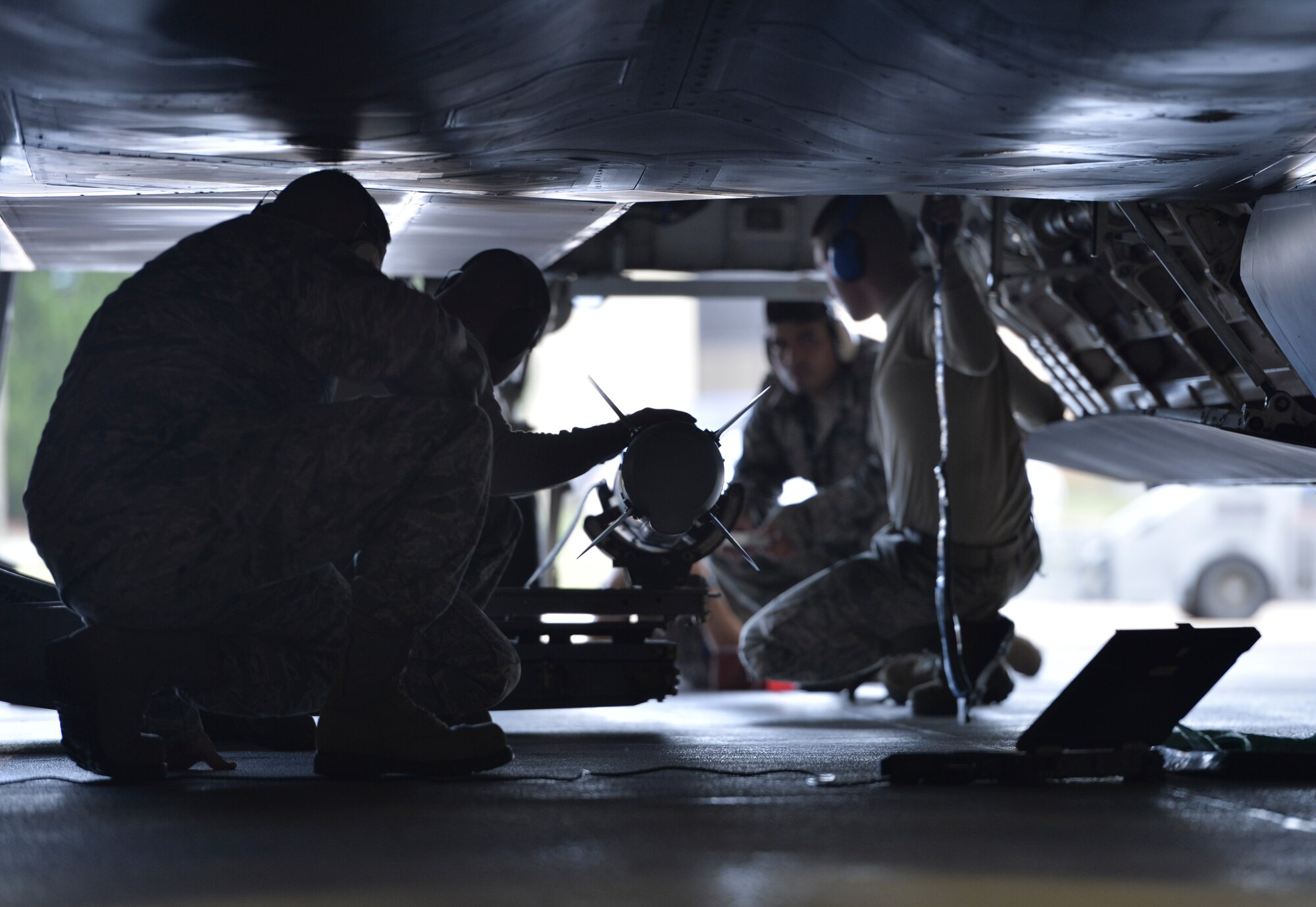U.S. Air Force Airmen from the 43rd Aircraft Maintenance Unit prepare to load a training missile into an F-22 Raptor during the Load Crew of the Year competition at Tyndall Air Force Base, Fla., Jan. 20, 2017. Evaluation team members graded the teams of Airmen on timeliness, safety and reliability. (U.S. Air Force photo by Tech. Sgt. Javier Cruz/Released)
