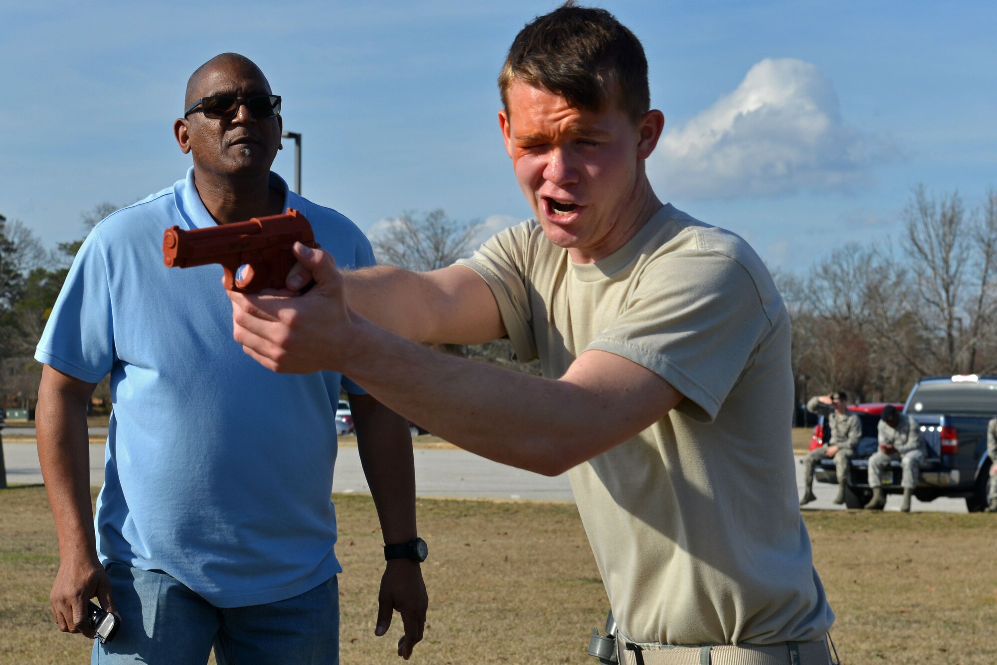 U.S. Air Force Airman 1st Class Austin Reese, 20th Security Forces Squadron entry controller, aims an artificial training weapon at a simulated attacker during his pepper spray training while Karl Johnson, 20th SFS trainer, motivates him to continue at Shaw Air Force Base, S.C., Jan. 18, 2017. During a use of force training day, Airmen reviewed less-lethal weapons, operational security and identification procedures, to include the new Real ID Act changes. Although some of the training was classroom-based, the Airmen also performed baton drills and situational use of force training. Team Shaw defenders who had not yet experienced pepper spray first-hand were required to complete an obstacle course while affected by the substance. (U.S. Air Force photo by Airman 1st Class Destinee Sweeney)