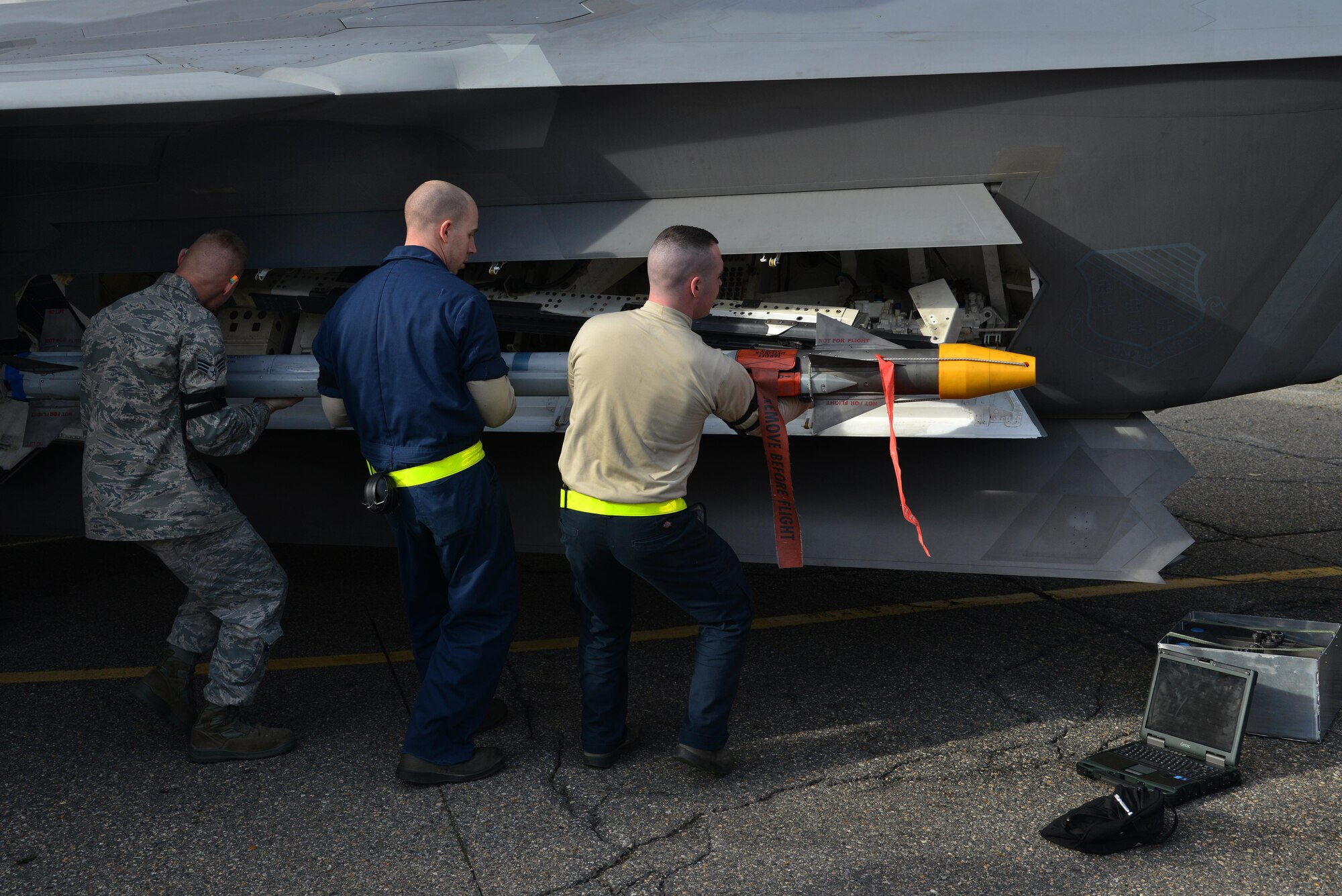 Members from the 27th Aircraft Maintenance Unit team load an AIM-9X missile onto an F-22 Raptor during the 1st Maintenance Squadron Weapons Load Crew of the Year competition at Joint Base Langley-Eustis, Va., Jan. 13, 2017. Weapons Standardization members evaluated the load crews during the competition, and the crew with the least amount of discrepancies and fastest time won. (U.S. Air Force photo by Airman 1st Class Tristan Biese)