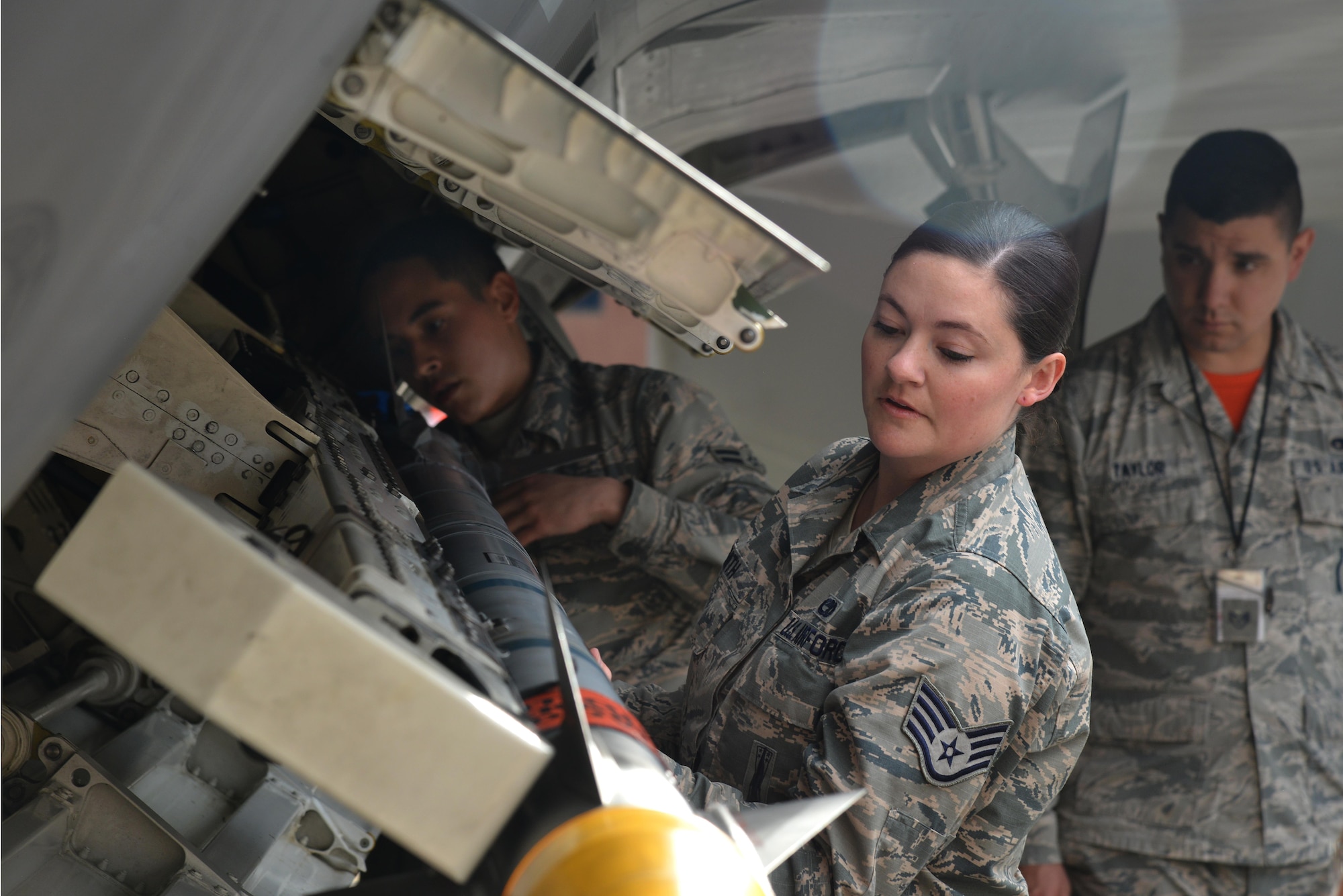 U.S. Air Force Airman 1st Class Julian Lopez, 94th Aircraft Maintenance Unit weapons load crew member, and U.S. Air Force Staff Sgt. Reata Smith, 94th Aircraft Maintenance Unit weapons load crew member team chief, load an AIM-9X missile onto an F-22 Raptor during the 1st Maintenance Squadron Weapons Load Crew of the Year competition at Joint Base Langley-Eustis, Va., Jan. 13, 2017. Each team member is hand-picked by their unit to represent their respective AMUs during the competition. (U.S. Air Force photo by Airman 1st Class Tristan Biese)