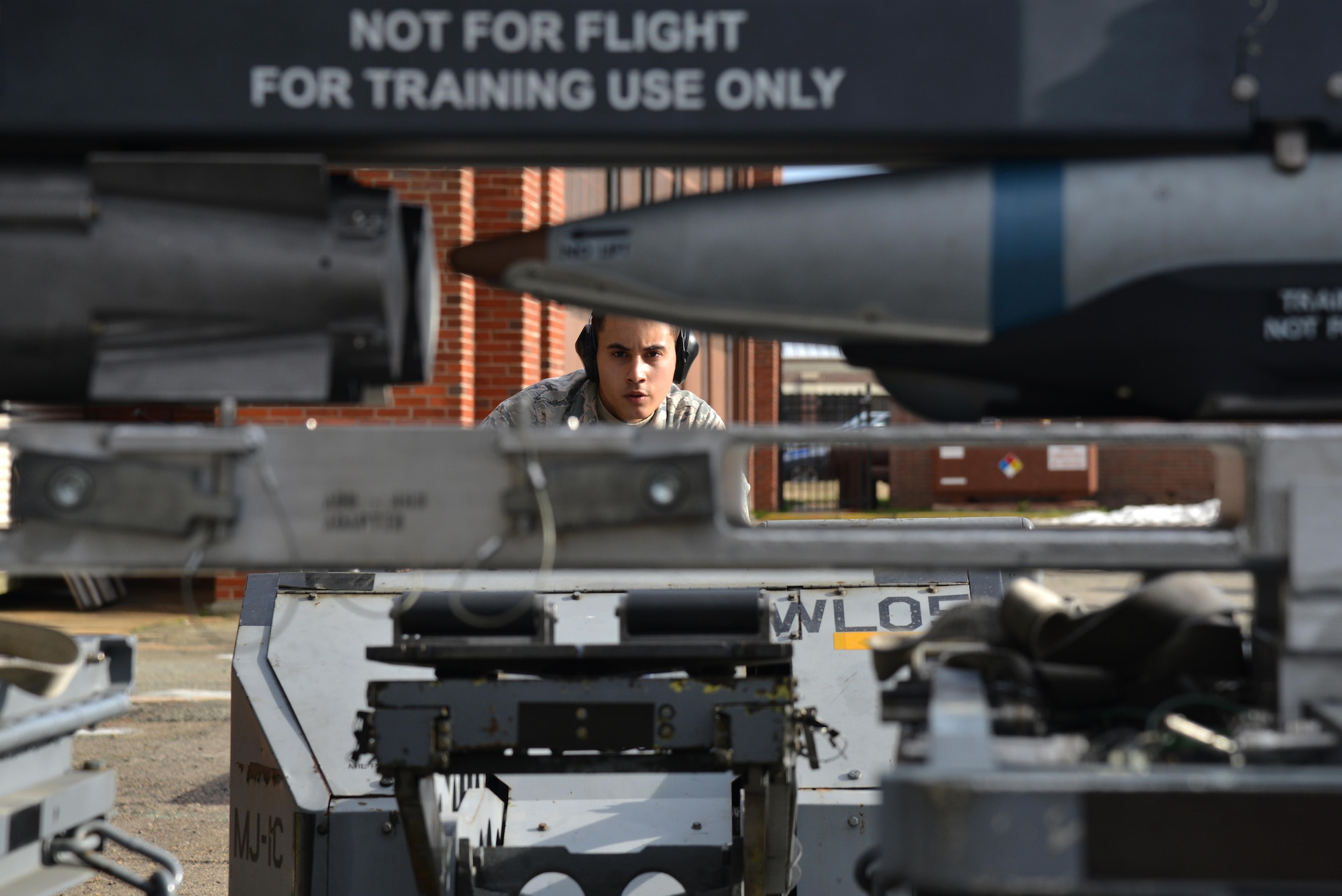 U.S. Air Force Airman 1st Class Julian Lopez, 94th Aircraft Maintenance Unit weapons load crew member, operates a bomb lift during the 1st Maintenance Squadron Weapons Load Crew of the Year competition at Joint Base Langley-Eustis, Va., Jan. 13, 2017. The lift was used during the competition to load a preloaded BRU-61 with four GBU-39 missiles onto an F-22 Raptor. (U.S. Air Force Photo by Airman 1st Class Tristan Biese)