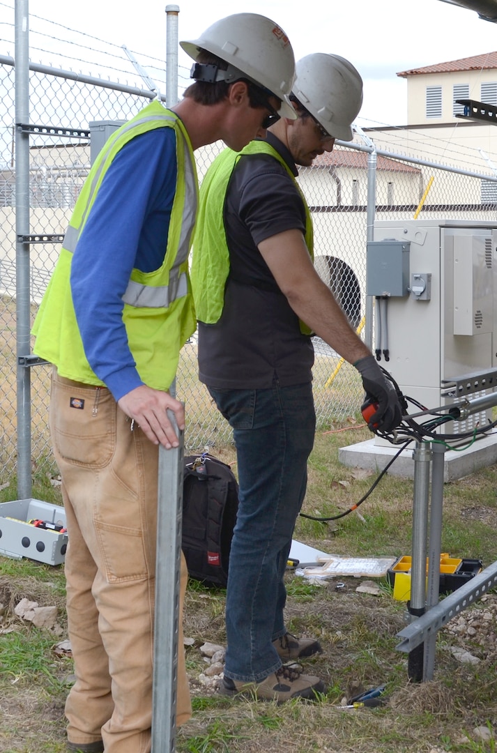 Cord Brown (left) and Daniel Moyer (right), technicians with Cam Solar, install a replacement inverter at one of the solar arrays at the microgrid test site Jan. 13 at the JBSA-Fort Sam Houston Campbell Memorial Library. The test site was installed as part of a collaborative effort between JBSA and CPS Energy to research the uses and effectiveness of microgrid technology, which has the capability of producing energy for the library while using solar power without being connected to the electric grid.