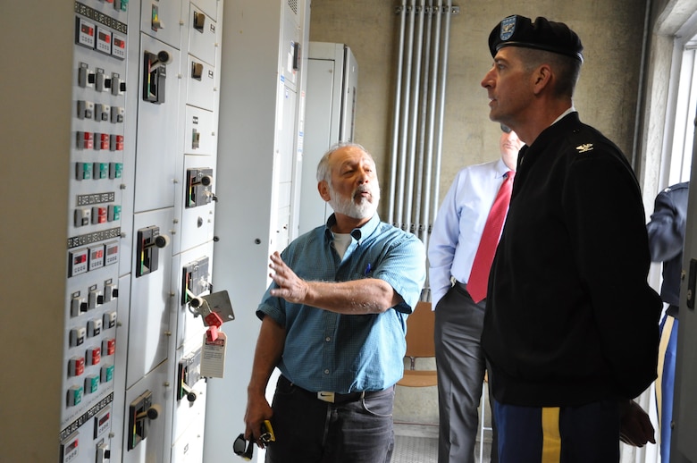 Louis Munoz, dam tender supervisor for the Corps' Los Angeles District, describes the operation of Prado Dam's upgraded regulating outlet gates to South Pacific Division Commander Col. Pete Helmlinger during a Jan. 18 visit to the dam's control tower in Corona, California.