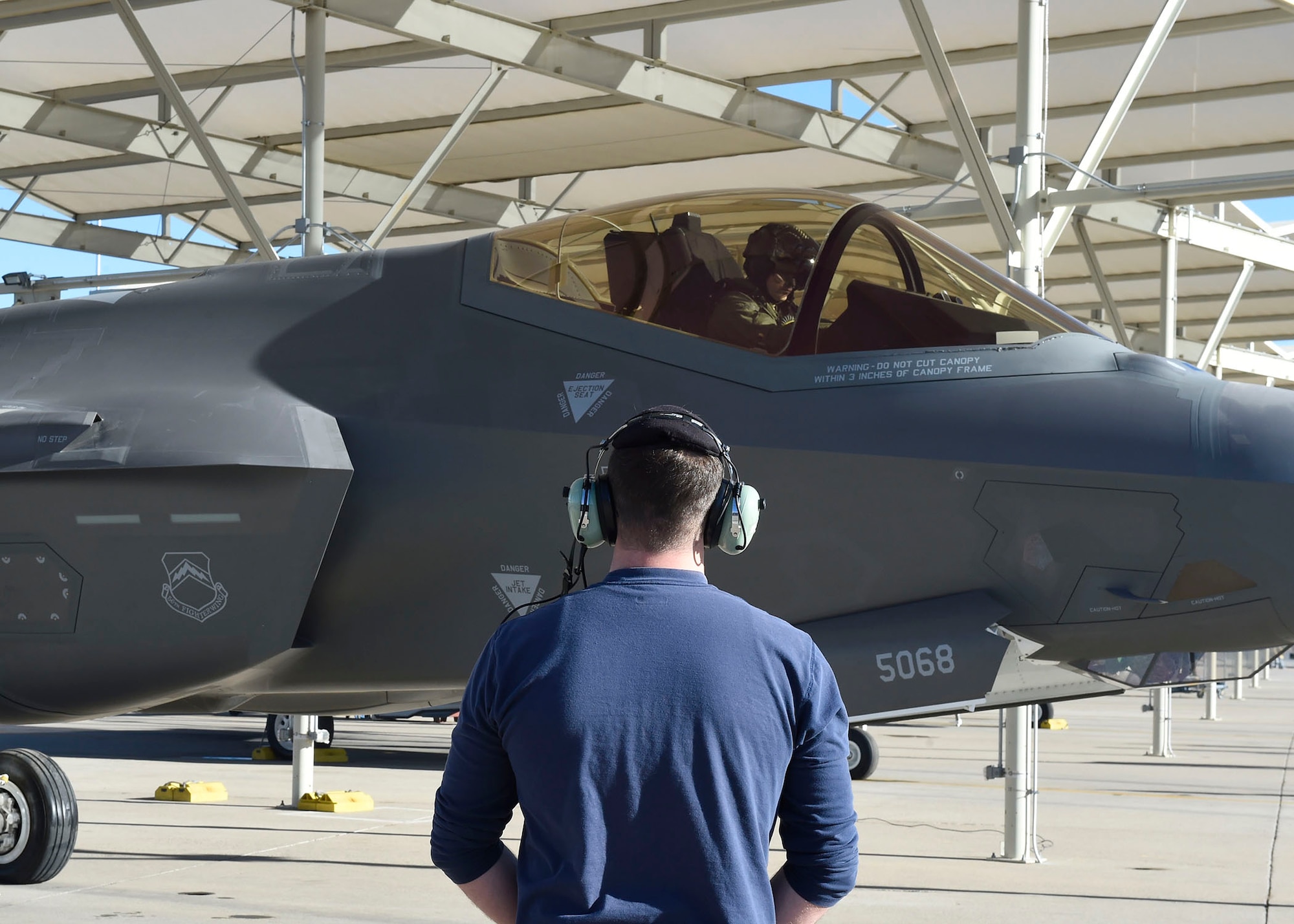 Chad Thomson, 62nd Aircraft Maintenance Unit Lockheed Martin crew chief, stands by to marshal an F-35 Lightning II Jan. 24, 2017, at Luke Air Force Base, Ariz. The 62nd AMU is in the process of integrating Airmen into its maintenance operations. (U.S. Air Force photo by Senior Airman James Hensley)
