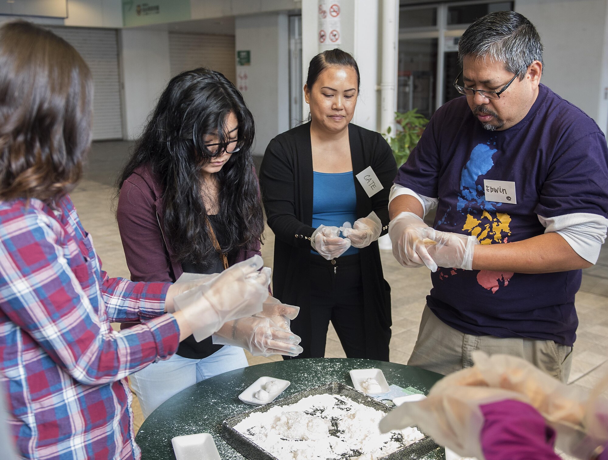 Members of the Kadena Teen Center and Okinawa City junior high school use a wooden mallet to pound rice to make mochi Jan. 21, 2017, at Koza Music City, Okinawa, Japan. The Let’s Learn English exchange builds relationships between Okinawan and American teenagers. (U.S. Air Force photo by Airman 1st Class Corey Pettis/Released) 
