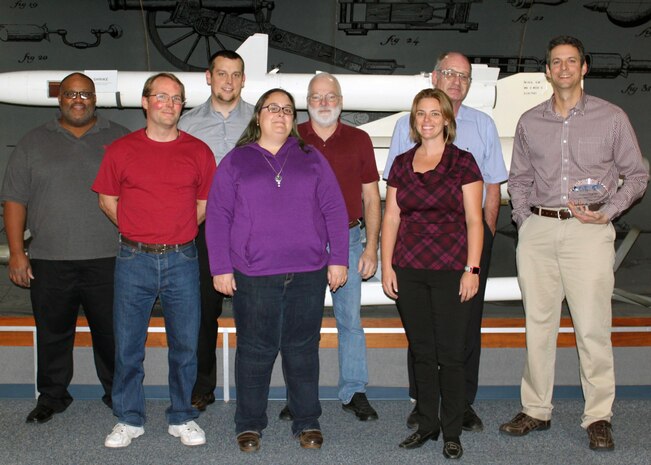 Dr. Benjamin Harvey, right, celebrates with his Naval Air Warfare Center Weapons Division teammates Jan. 12 in China Lake after winning the Strategic Environmental Research and Development Program 2016 Project-of-the-Year Award. From left are Dr. Lawrence Baldwin, Dr. Matthew Davis, Michael Garrison, Dr. Heather Meylemans, Dr. Thomas Groshens, Dr. Lee Cambrea, Andrew Chafin, and Harvey.