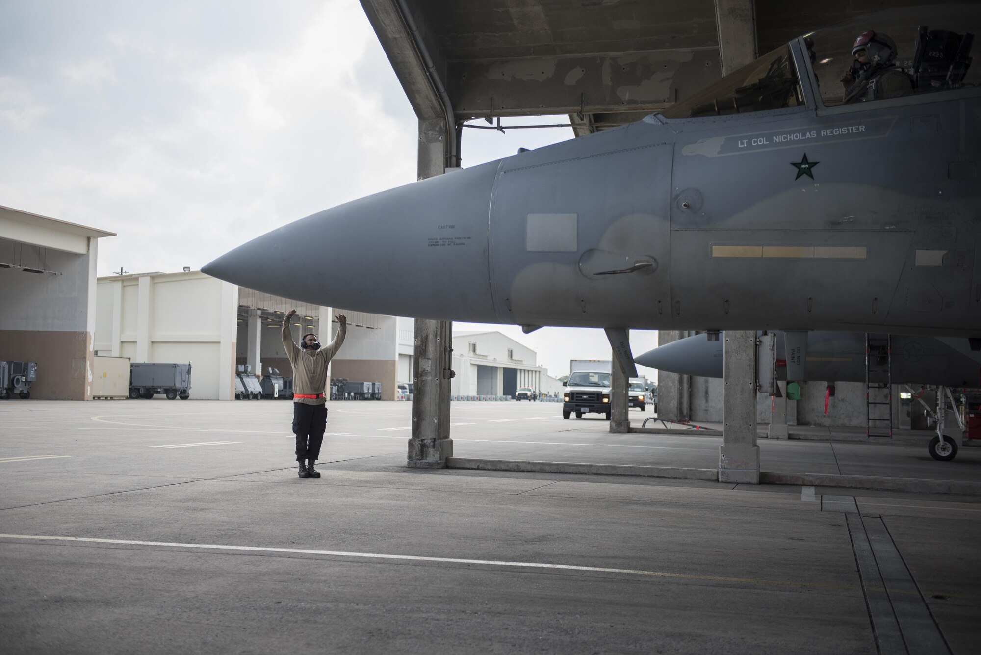U.S. Air Force Senior Airman Christopher Hill, 67th Aircraft Maintenance Unit crew chief, signals for an F-15 Eagle to pull out onto the flightline Jan 10, 2017, at Kadena Air Base, Japan. The 67th AMU maintainers are capable of servicing an aircraft and getting it back into the air in minutes. (U.S. Air Force photo by Senior Airman Omari Bernard/Released)