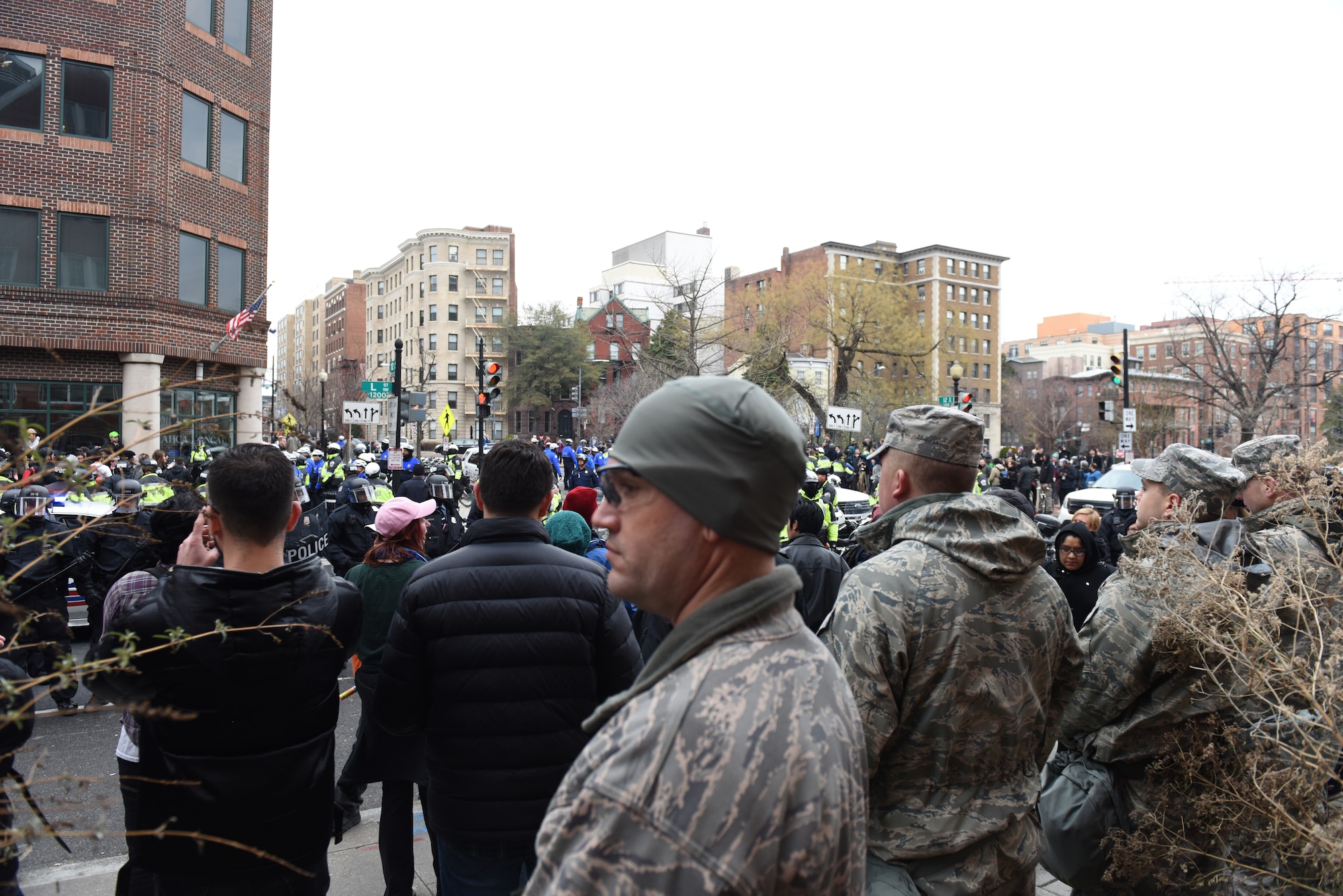 Pennsylvania Air National Guardsmen man a traffic control point in Washington, D.C., Jan. 20, 2017, while protesters are detained by police after hurling rocks, metal debris and a hammer toward law enforcement officials. More than 1,000 PANG Soldiers and Airmen headed to D.C. to support a safe, secure inauguration. They joined more than 7,000 Guardsmen from 44 states. (U.S. Air National Guard photo by 2nd Lt. Susan Penning/Released) 