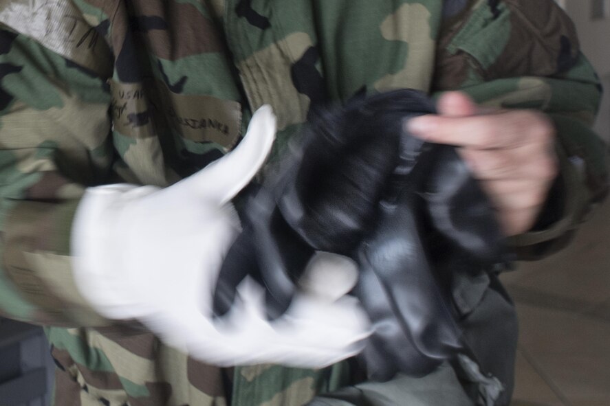A 374th Airlift Wing Airman  dons a Mission-Oriented Protective Posture gear during a Samurai Readiness Training Day at Yokota Air Base, Japan, Jan. 23, 2017. Airmen must quickly and correctly don MOPP gear. (U.S. Air Force photo by Yasuo Osakabe)