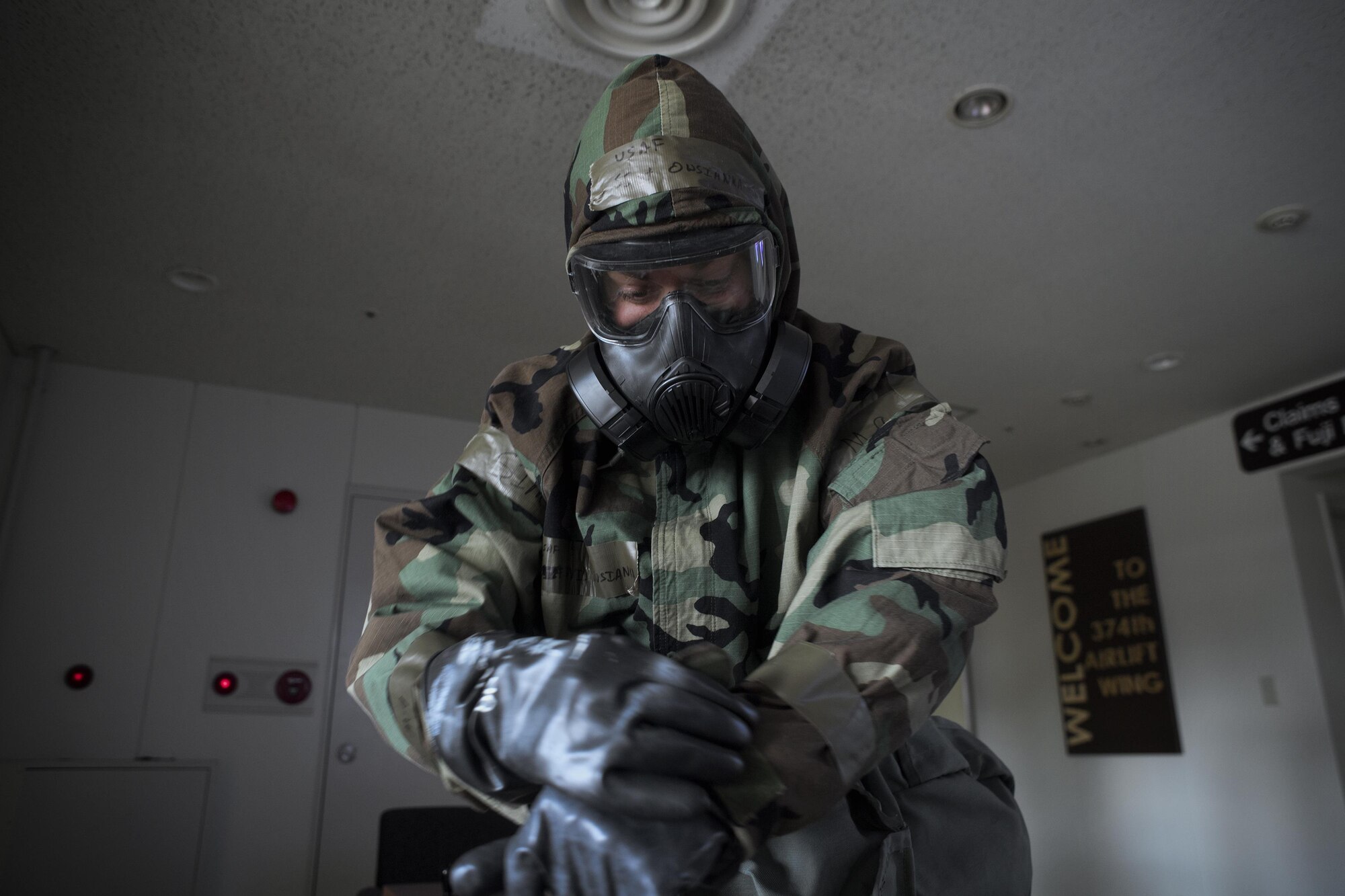 Staff Sgt. David Owsanka, 374th Airlift Wing public affairs photojournalist, dons  Mission-Oriented Protective Posture gear during a Samurai Readiness Training Day at Yokota Air Base, Japan, Jan. 23, 2017. Airmen must quickly and correctly don MOPP gear. (U.S. Air Force photo by Yasuo Osakabe)