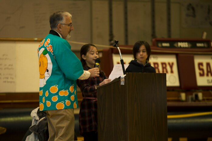 Hana Cahill, a student at Matthew C. Perry Elementary School, reads a letter of appreciation during the seventh annual mikan presentation at Marine Corps Air Station Iwakuni, Japan, Jan. 19, 2017. The letters were prepared in English and Japanese. Some students made personalized gift bags, and the host nation class showed their gratitude by holding up signs that read “Thank you for the delicious mikans!” in Japanese, English and Spanish. Local farmers presented the sweet, easy-to-peel citrus fruit, which is similar to Mandarin oranges, to students expanding their experience of Japanese cultures. (U.S. Marine Corps photo by Lance Cpl. Gabriela Garcia-Herrera)