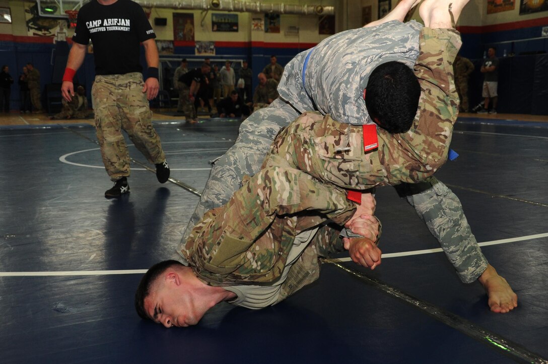 Senior Airman Dominic Rivera, 386th Expeditionary Maintenance Squadron craftsman, top, battles Spc. James Holder, 518th Tactical Installation Network, bottom, January 22, 2017 during an Army combatives tournament at an undisclosed location in Southwest Asia. The tournament tested the mixed martial arts skills of Airmen and Soldiers in a competitive environment. (U.S. Air Force photo/Tech. Sgt. Kenneth McCann)