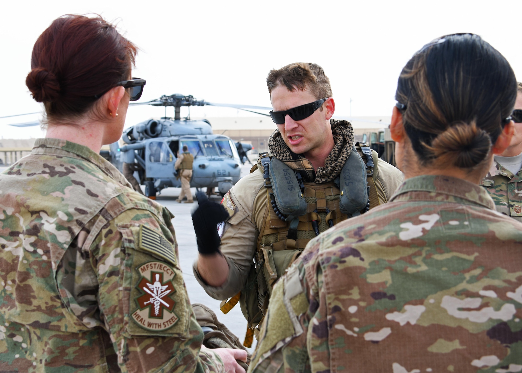 U.S. Navy Petty Officer 2nd Class Nick Flynn, a naval aircrewman assigned to Helicopter Sea Combat Squadron 26, gives a flight safety briefing to members of the 379th Expeditionary Medical Operations Squadron mobile field surgical and expeditionary critical care teams at Al Udeid Air Base, Qatar, Jan. 23, 2016. The medical team departed onboard two SH-60 Seahawks to join Royal Navy forces aboard the HMS Ocean for a coalition exercise where they will simulate providing care to casualties at sea. (U.S. Air Force photo by Senior Airman Miles Wilson)