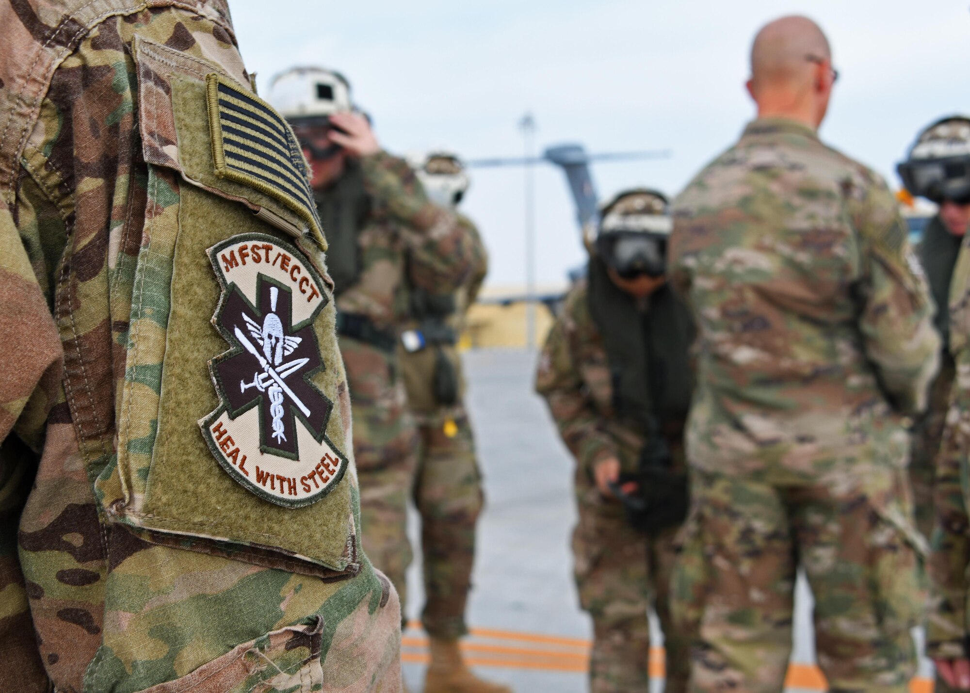 U.S. Air Force Airmen of the 379th Expeditionary Medical Operations Squadron put on safety equipment during a flight safety briefing at Al Udeid Air Base, Qatar, Jan. 23, 2017. These members made up one of the mobile field surgical teams - expeditionary critical care teams at Al Udeid Air Base, and traveled to the HMS Ocean, a Royal Navy ship, to be part of a coalition exercise. (U.S. Air Force photo by Senior Airman Miles Wilson)