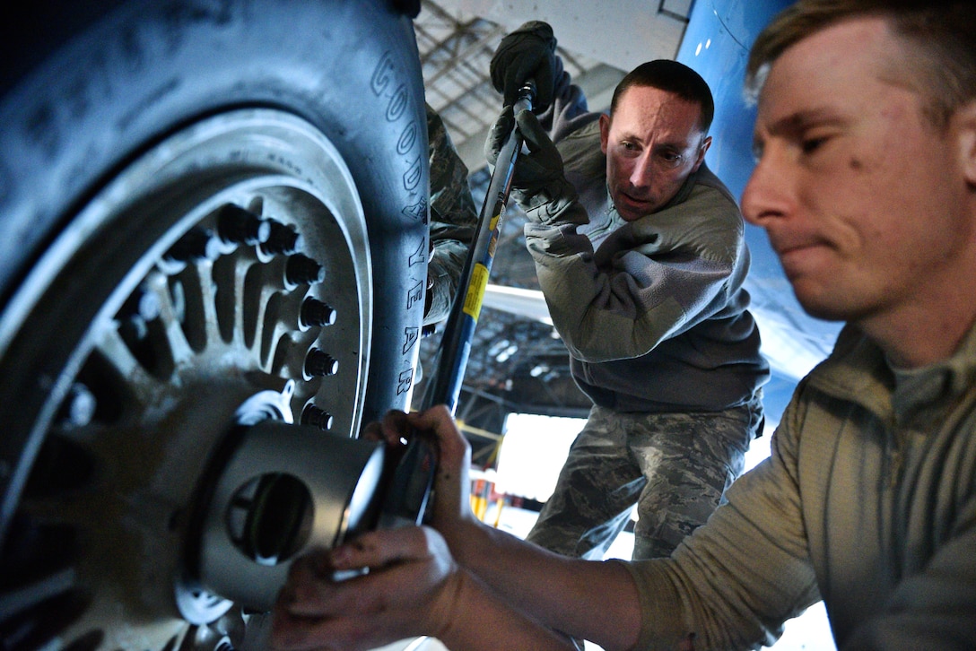 Tech. Sgt. Steven Johnson adjusts the tension as Staff Sgt. Damian Ford, both with the 932nd Maintenance Squadron, assists by helping to hold the oversize wrench in place during a routine tire swap Dec. 29, 2016, Scott Air Force Base, Illinois.  "Changing a C-40 tire is very similar to changing a car tire, just bigger with a few more required adjustments," said Johnson.  (U.S. Air Force photo by Christopher Parr)