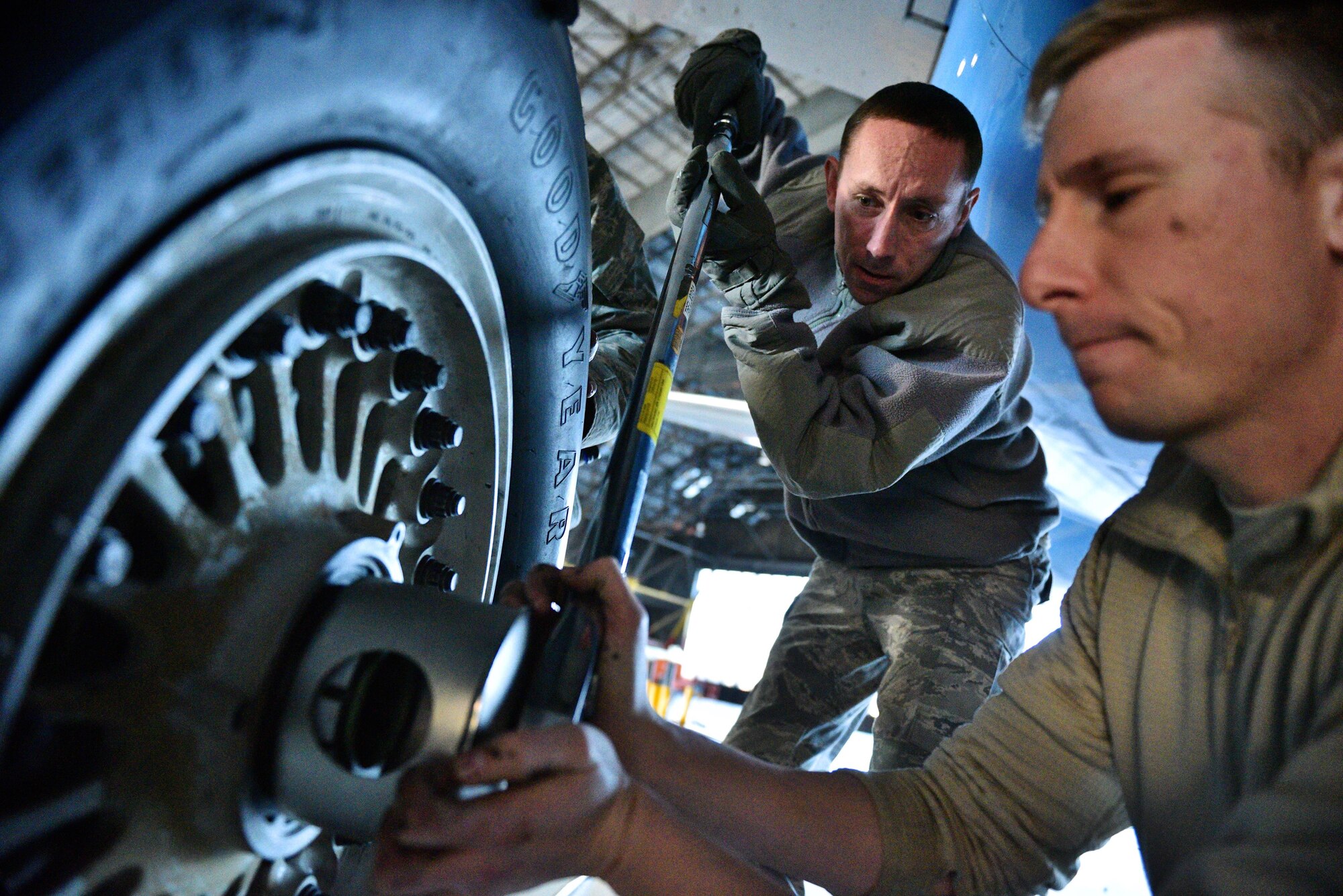 Tech. Sgt. Steven Johnson adjusts the tension as Staff Sgt. Damian Ford, both with the 932nd Maintenance Squadron, assists by helping to hold the oversize wrench in place during a routine tire swap Dec. 29, 2016, Scott Air Force Base, Illinois.  "Changing a C-40 tire is very similar to changing a car tire, just bigger with a few more required adjustments," said Johnson.  (U.S. Air Force photo by Christopher Parr)