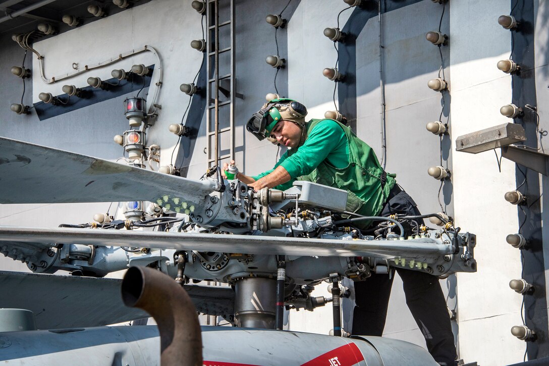 Navy Petty Officer 3rd Class Jose Luis Luzania performs routine maintenance on an MH-60S Seahawk on the flight deck of the aircraft carrier USS Carl Vinson in the Pacific Ocean, Jan. 19, 2017. Luzania is an aviation electrician’s mate. Navy photo by Seaman Jake Cannady