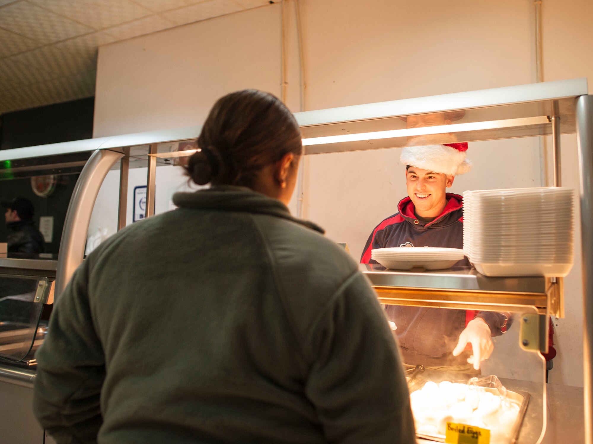 Capt. Michael Voto, 332nd Expeditionary Security Forces Squadron flight commander, serves pancakes to an Airman at the dining facility Dec. 25, 2016, at an undisclosed location in Southwest Asia. The company grade officer council served Christmas Day breakfast to the soldiers and Airmen. (U.S. Air Force photo by Staff Sgt. Eboni Reams)