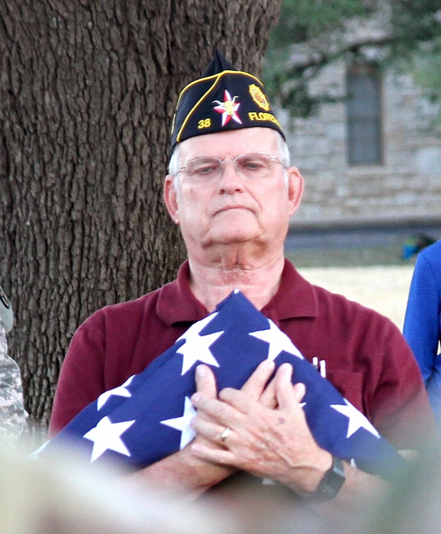 Tom Moody, a member of American Legion Post 38 in Floresville, Texas, holds a U.S. flag at the Joint Base San Antonio-Fort Sam Houston Quadrangle Clock Tower Jan. 23. The flag Moody held is one of four that a detail of Soldiers from the Army Medical Department Center & School and the Army North Caisson Platoon volunteered to raise, lower, and fold the flags for the post. The flags will be presented as part of the post’s “Lest We Forget” program to commemorate the raid on Cabanatuan prisoner of war camp in the Philippines Jan. 30, 1945.