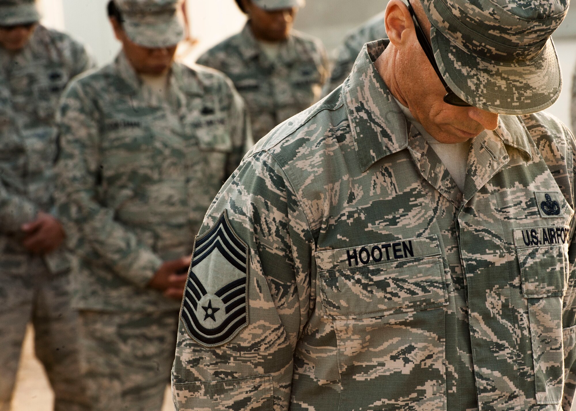 U.S. Air Force Chief Master Sgt. Darrin Hooten, 332nd Expeditionary Mission Support Group superintendent, bows his head in prayer during a retreat ceremony Dec. 30, 2016, in Southwest Asia. The retreat ceremony serves as a sign of the end of the duty day and pays respect to the U.S. national flag. (U.S. Air Force photo by Staff Sgt. Eboni Reams)