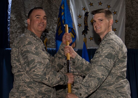 U.S. Air Force Capt. Tyler Freeman, 332nd Expeditionary Force Support Squadron incoming commander, receives command from Col. Daniel Guinan, 332nd Expeditionary Mission Support Group commander, during a change of command ceremony Jan. 5, 2017, at an undisclosed location in Southwest Asia. (U.S. Air Force photo by Staff Sgt. Eboni Reams/Released)