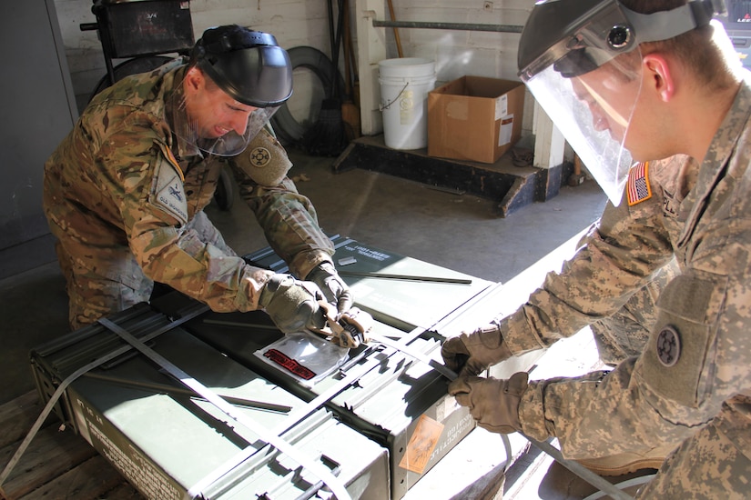 Spc. Travis Omps and Pfc. Trey Triplett of the 321st Ordnance Battalion, use banding material to fasten a munitions container to a pallet at the Logistics Readiness Center-APG Shipping & Receiving Bldg. 714 during the Excess Ammo Operation Clean Sweep Mission at Aberdeen Proving Ground, Md. Dec. 14, 2016. 