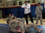 Master Sgt. Royce Kerbow, the 386th Air Expeditionary Wing command post superintendent, coaches his students during an Army combatives tournament match at an undisclosed location in Southwest Asia Jan. 22, 2017. Kerbow prepared his students with daily Brazilian jujitsu workouts. (U.S. Air Force photo/Tech. Sgt. Kenneth McCann)