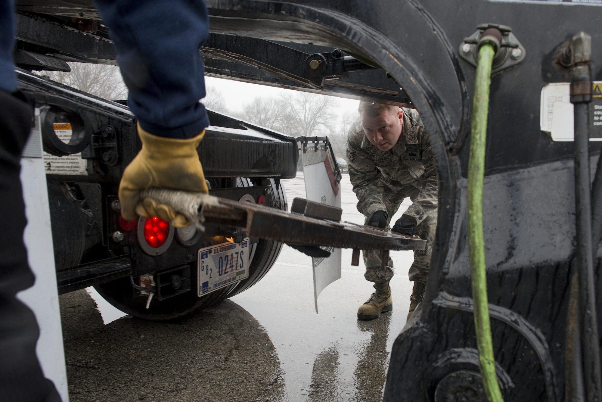 Staff Sgt. Joshua Meyer, 375th Logistics Readiness Squadron vehicle operations control center NCOIC, lifts the Meyer’s Bar onto the hitch of the lowboy Jan. 19 at Scott Air Force Base, Ill. The “Meyers Bar,” nicknamed after its inventor, Staff Sgt. Joshua Meyer, is a 5-foot reinforced steel bar that has been constructed to support a lowboy trailer’s hydraulic gooseneck hitch to prevent it from bending. (U.S. Air Force photo/Senior Airman Joshua Eikren)